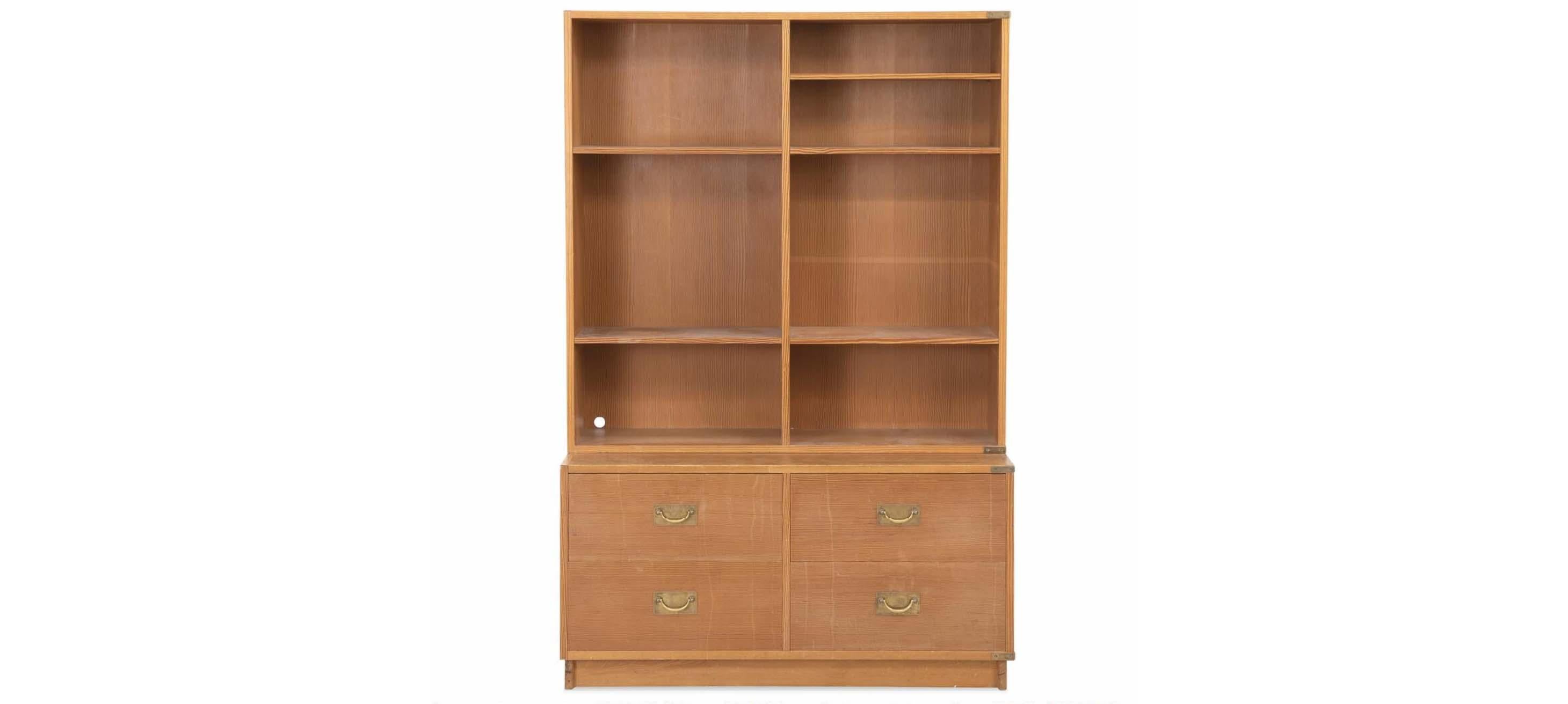 Danish pine wall unit of pitch pine consisting of bookcase and chest of drawers. Handles and fittings of brass. Normal patina due to age and use, including scratches, marks and notches. Hole in back.