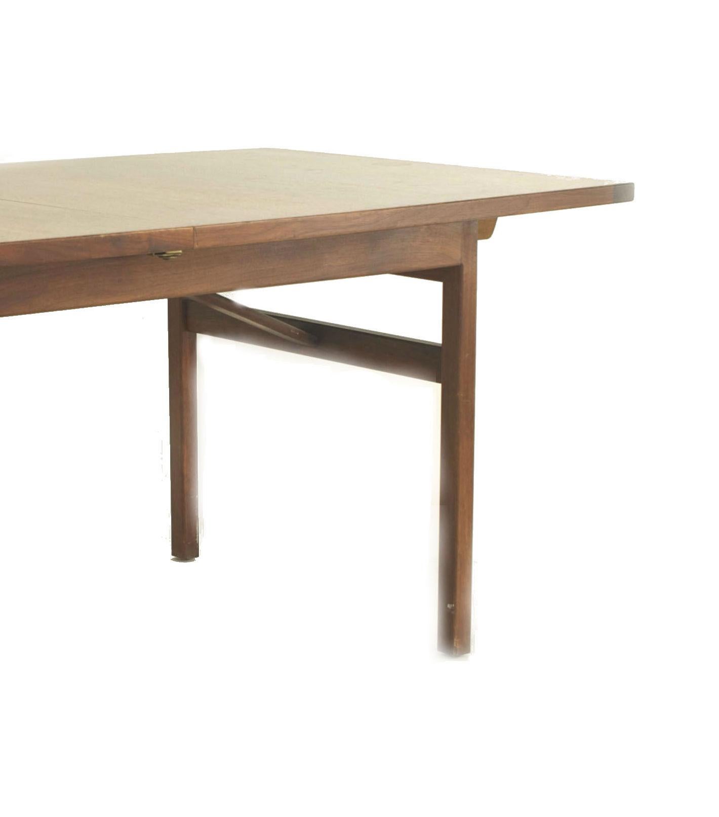 Danish Post-War Design teak dining table with a bowed design top and resting on square legs connected by a stretcher on either side. (label: JENS RISOM)
