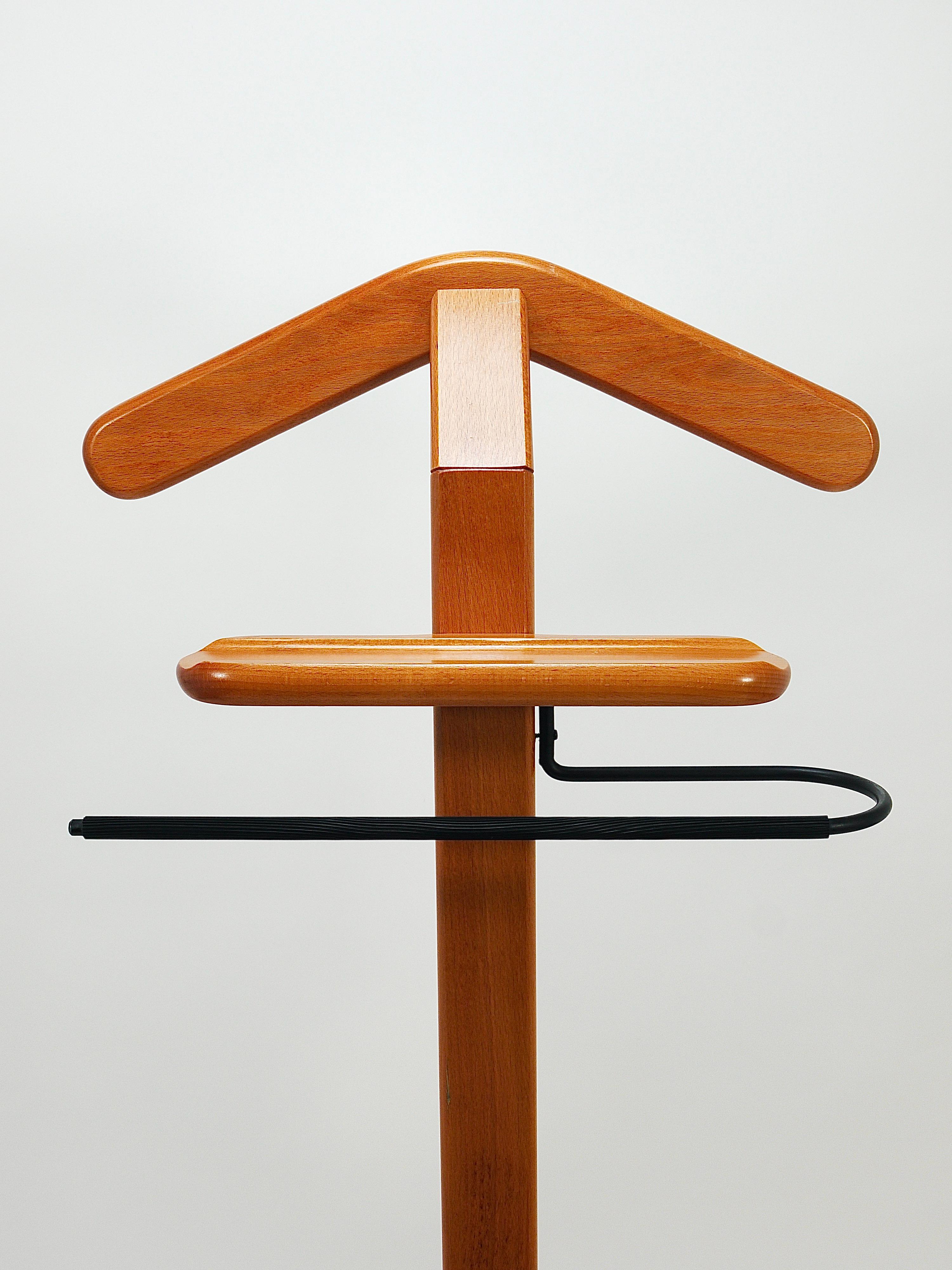 A sculptural postmodern valet clothing stand for both ladies and gentlemen from the 1980s, crafted in Denmark. Made of orange medium brown beech wood this stand includes a coat hanger, pant bar and necktie holder, designed to hold a jacket, shirt,