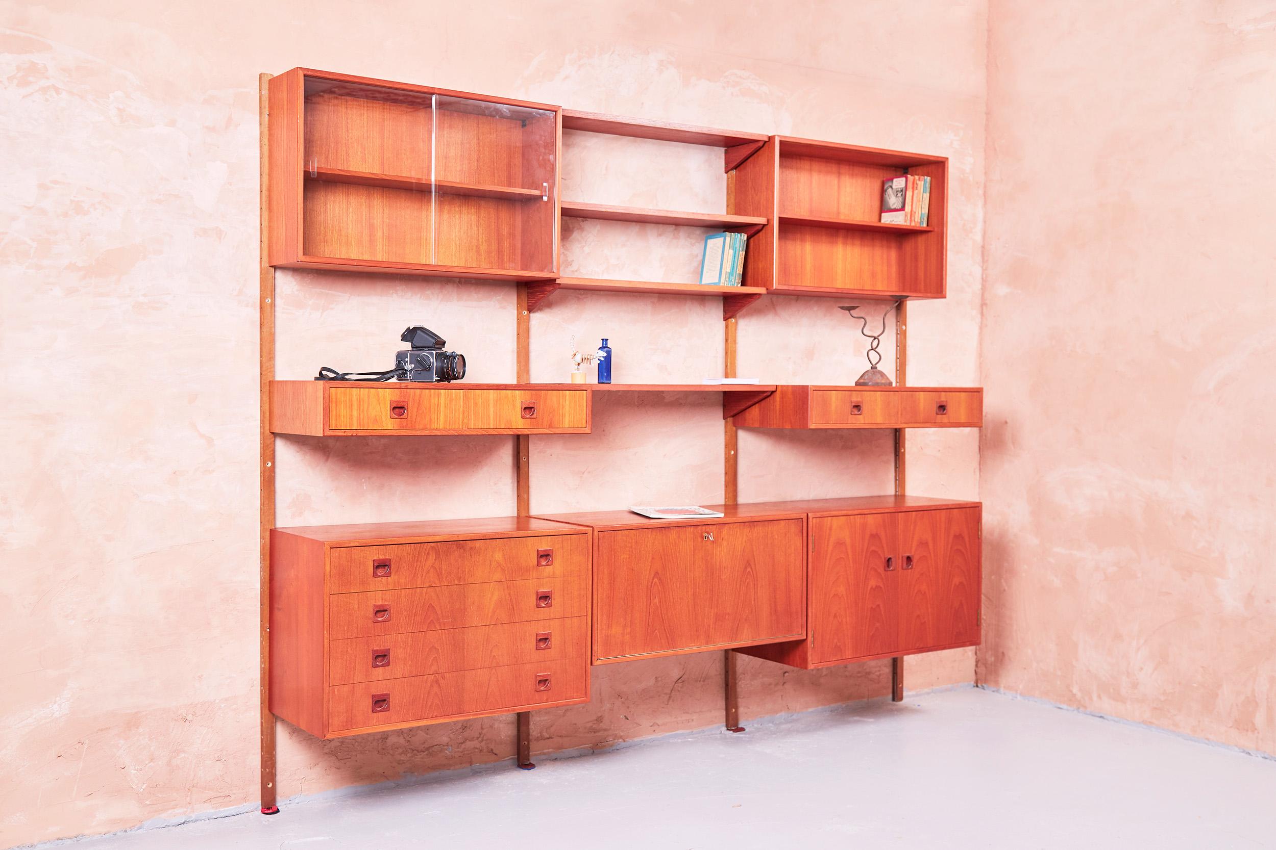 A Danish midcentury PS modular wall system designed by Peter Sorensen in the 1960s.
The Unit is constructed in teak, and is a really comprehensive collection of options, allowing for a really flexible arrangement. With another upright, you would