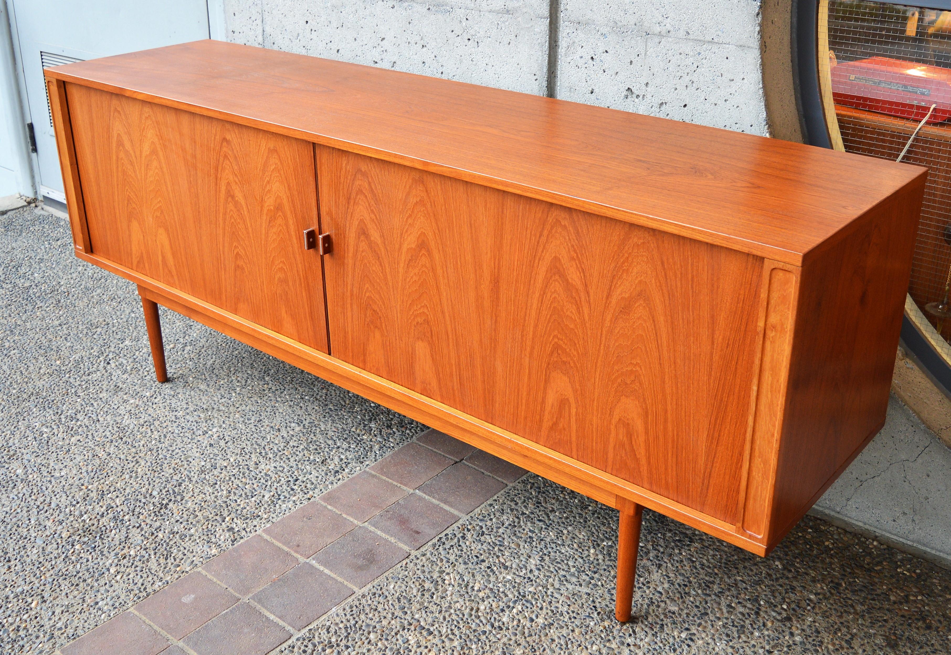This top quality Danish Modern teak buffet was designed by Peter Lovig Nielsen in 1969 for Dansk and has tambour doors that fold and disappear inside the cabinet with teak and chrome door pulls. Note the gorgeous solid wood base and apron, the