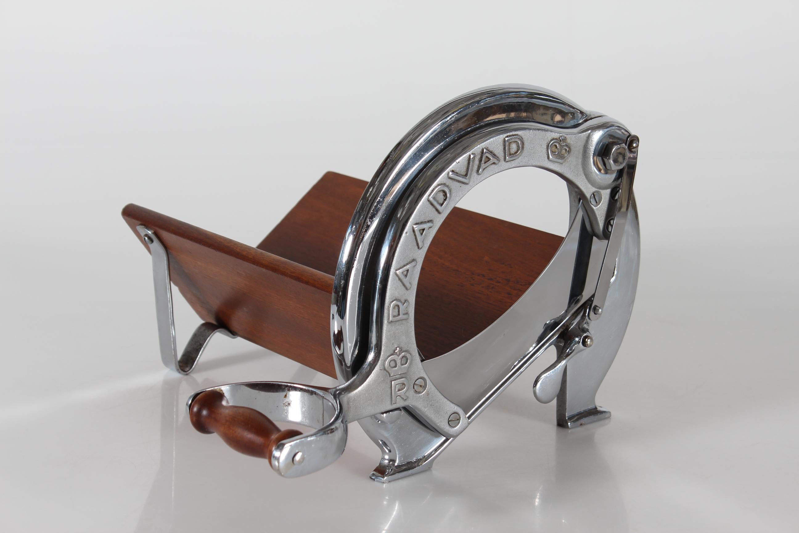 Original and rare Danish vintage bread slicer/cutter !

Manufactured by the famous Danish Company RAADVAD in the 1950s 
This special edition of model 294, long version, is of chromium-plated iron with board of mahogany

Raadvad is a reputable Danish