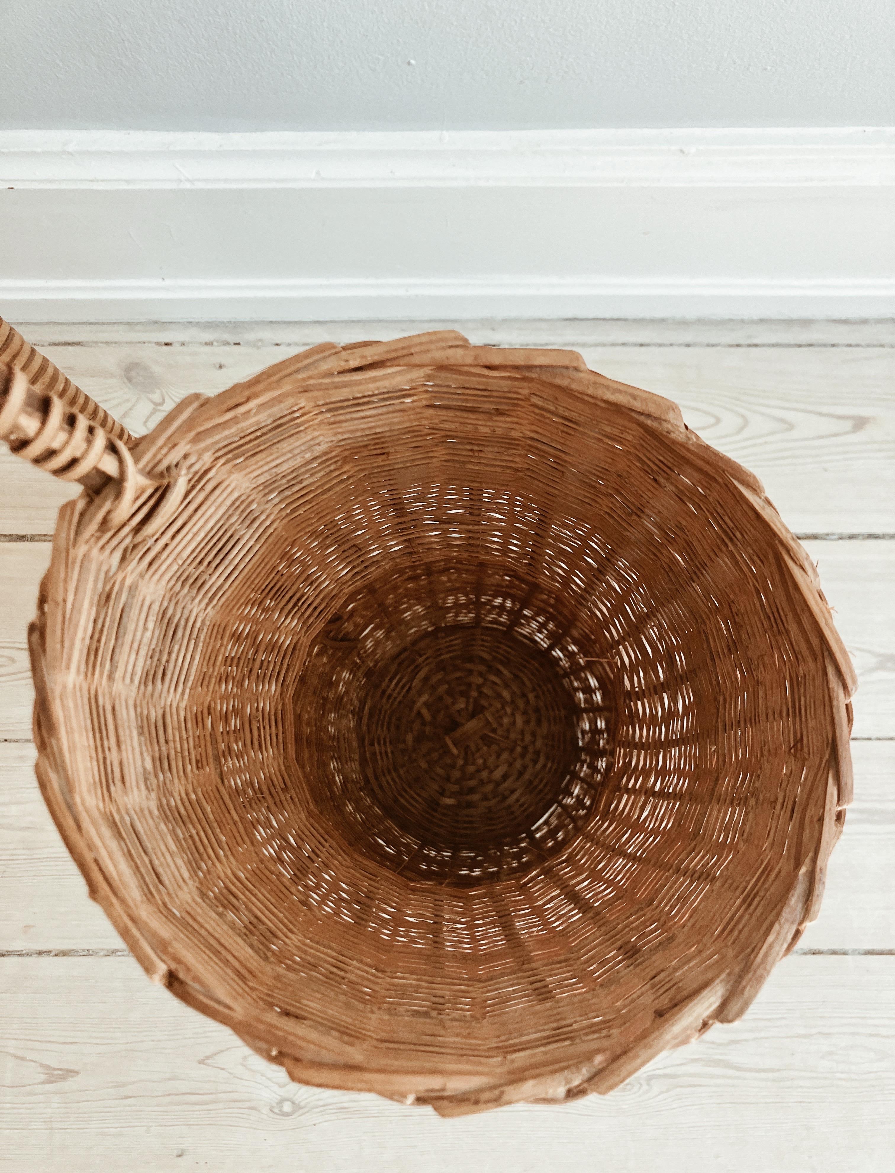 Danish vintage floor vase in rattan. For dried flowers or branches as water will destroy the rattan. 

You can place a tall glas vase inside the wicker vase and use it with water. 
