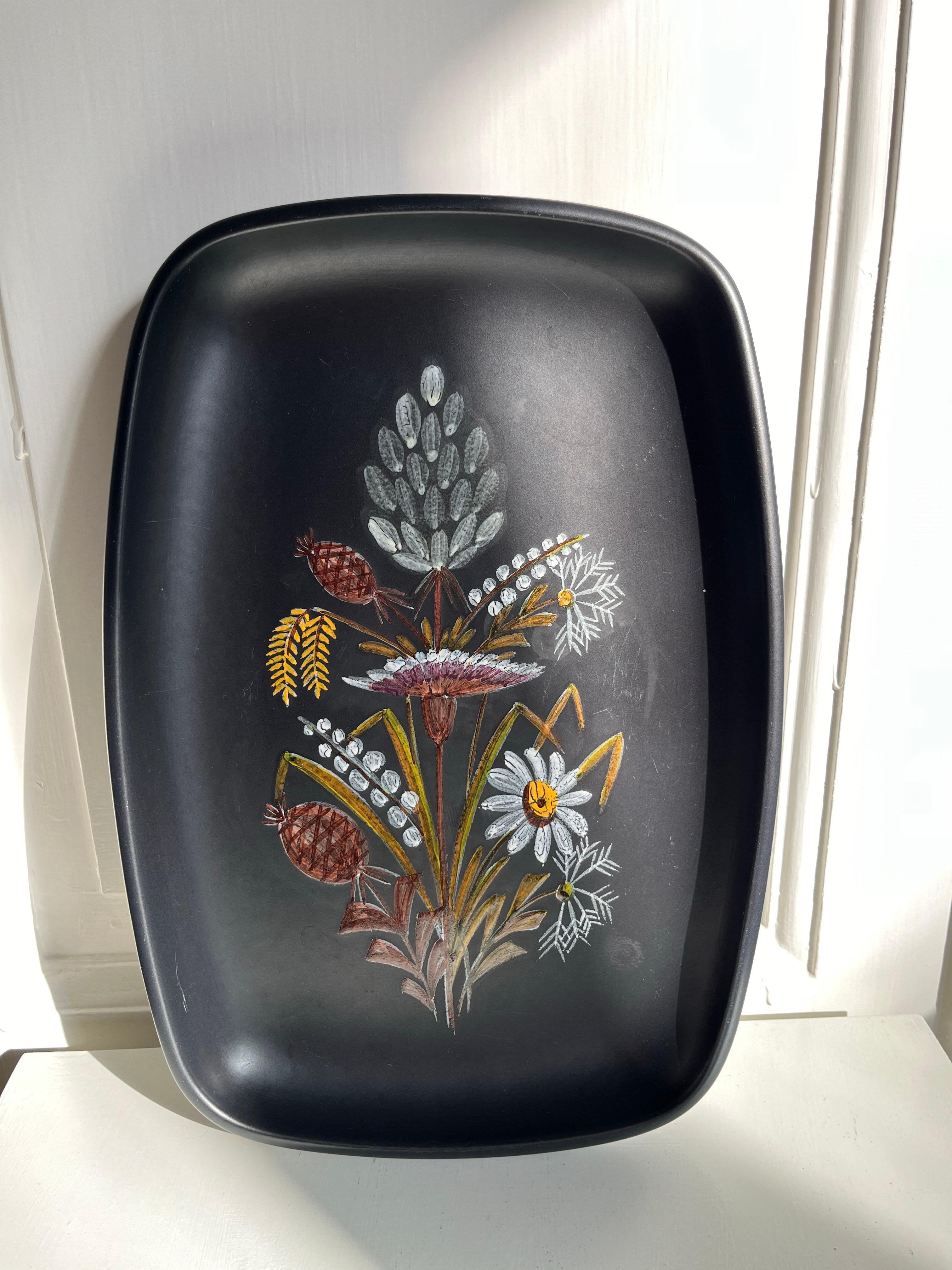 Plat danois en céramique Ravnild Keramik avec décorations florales, années 1960

Elegant plat en céramique du milieu du siècle de Ravnild Keramik, Danemark, années 1960. La pièce présente des formes douces et arrondies avec une base noire mate et