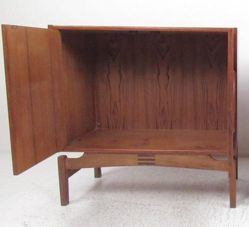 Danish made Mid-Century Modern cabinet in warm teak wood. Two doors with sculpted handles and rosewood joinery at the base. Beautifully designed and crafted.
Please confirm location NY or NJ.