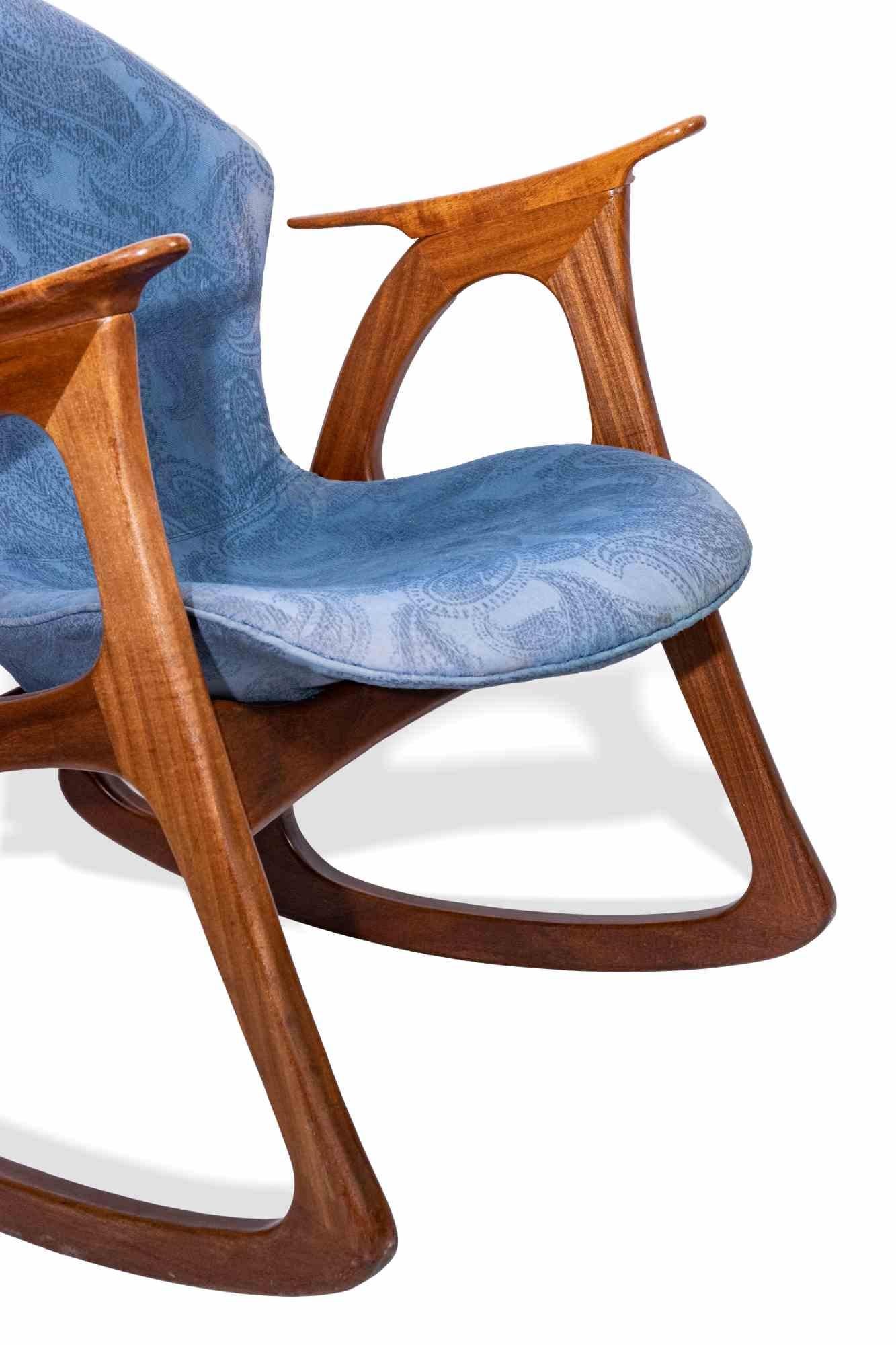 Danish rocking chair is an original design item designed by Aage Christiansen and manufactured by Erhardsen & Andersen in Denmark in the 1970s.

This chair is made of teak wood and covered by light blue fabric.

This elegant rocking chair is an