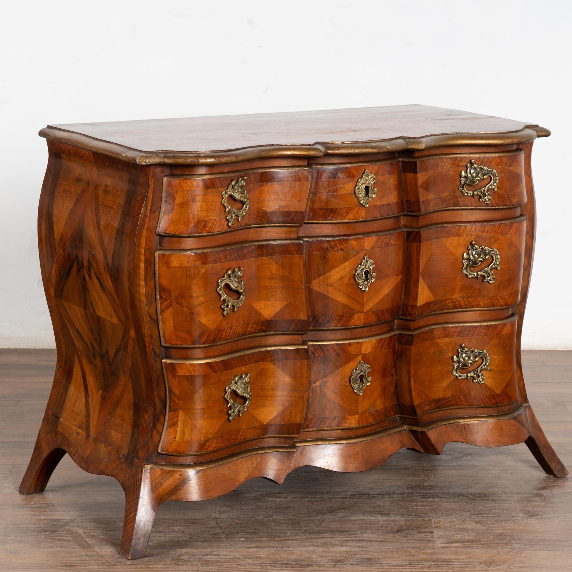 Commode danoise à bombay d'époque rococo avec marqueterie détaillée d'acajou et de noyer. 
Ce sont les courbes de Bombay et les pieds sabres tournant doucement vers l'extérieur qui attirent l'attention sur cette élégante commode dotée d'une belle
