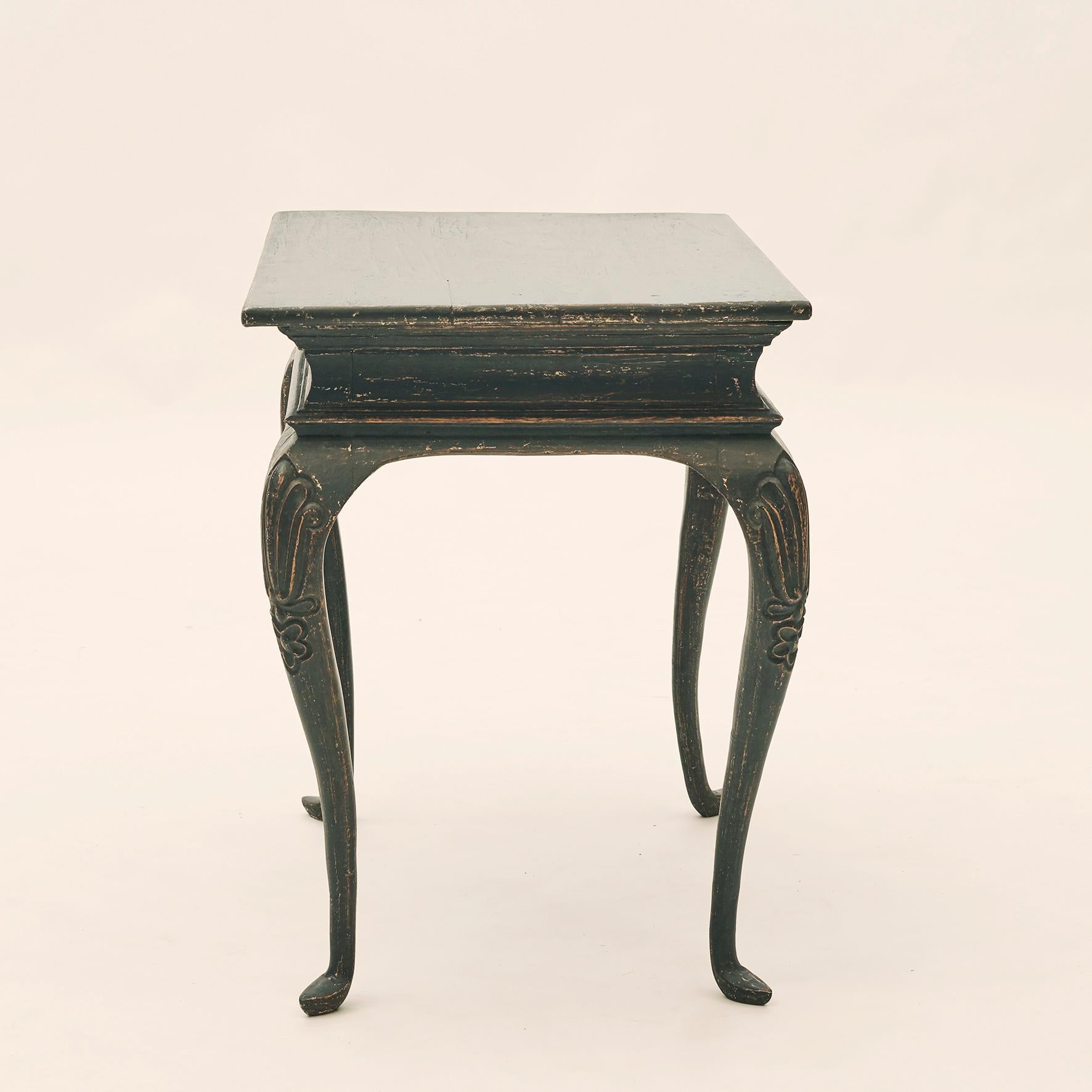 Rococo table black painted pine, good patina. Features a rectangular top with elegant apron. The table is raised on four cabriole legs with ornamented floral cuts at the top, Denmark, circa 1770.

This Danish Rococo side table from the 1770s has a