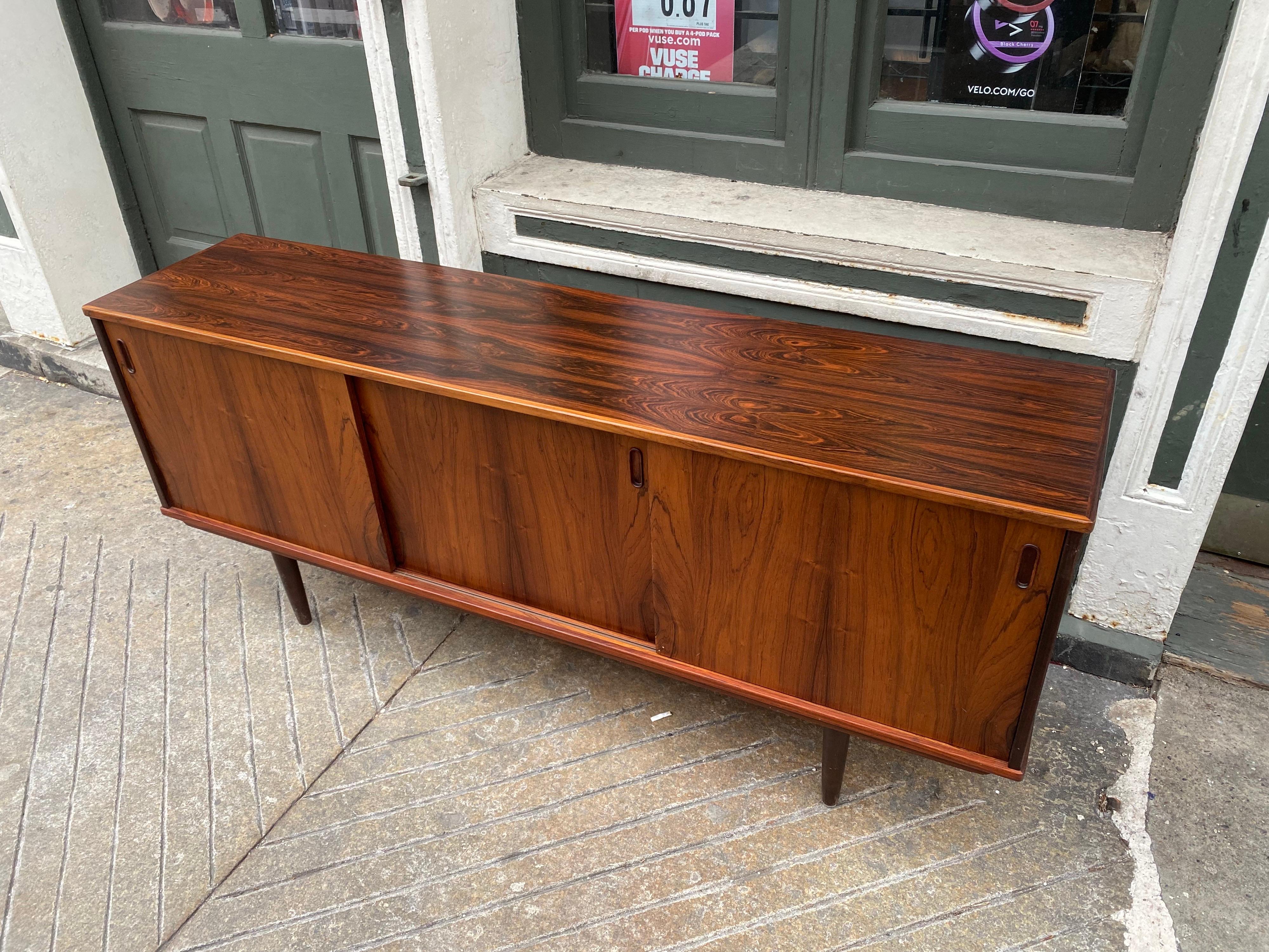 Rosewood 3 door Credenza. Doors slide easily to reveal 1 adjustable shelf in each opening. Veneer is very nice, all original with very expressive grain and color. Right side would of had two shallow pull out drawers that are missing.