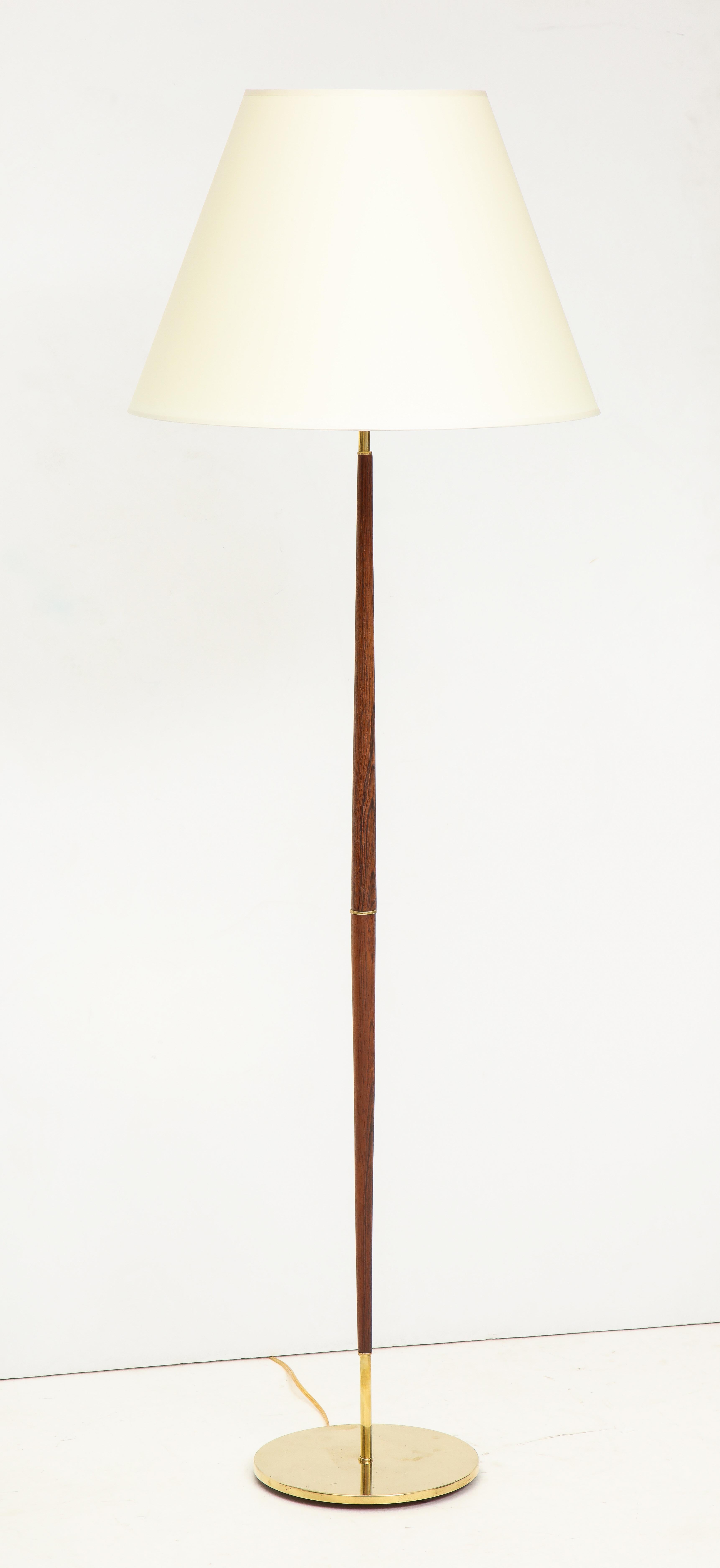 A Danish rosewood and brass floor lamp, with a spreading and tapered stem, circa 1960s, probably Fog & Mørup. Rewire for the USA. New shade. (19.75in.- diameter).