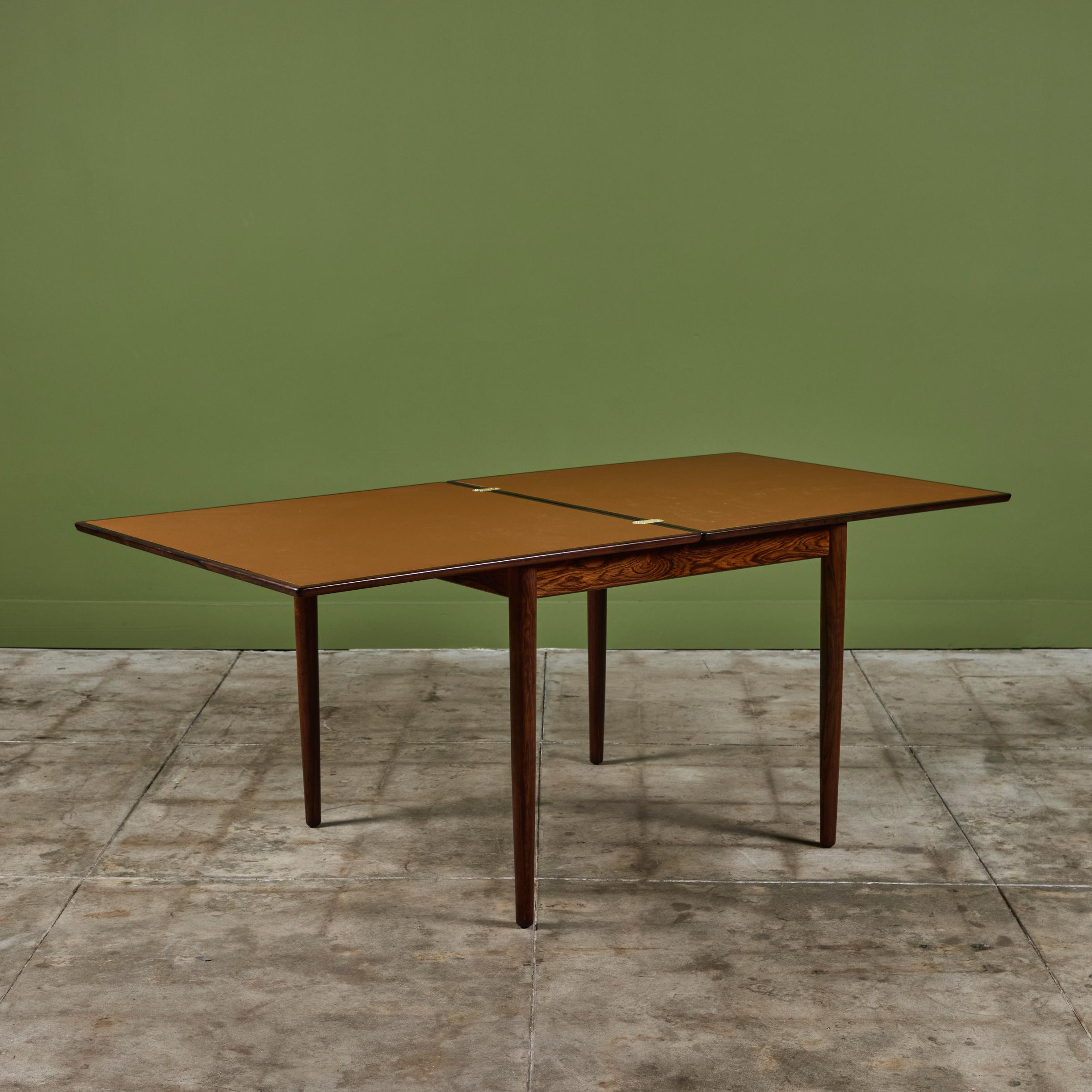 Mesa abatible danesa, c.1960. Esta mesa cuadrada tiene un tablero abatible que permite utilizarla como mesa de café/comedor o mesa de juegos. La mesa tiene marco y tablero de palisandro. Cuando está desplegada, la mesa presenta un tablero de cuero