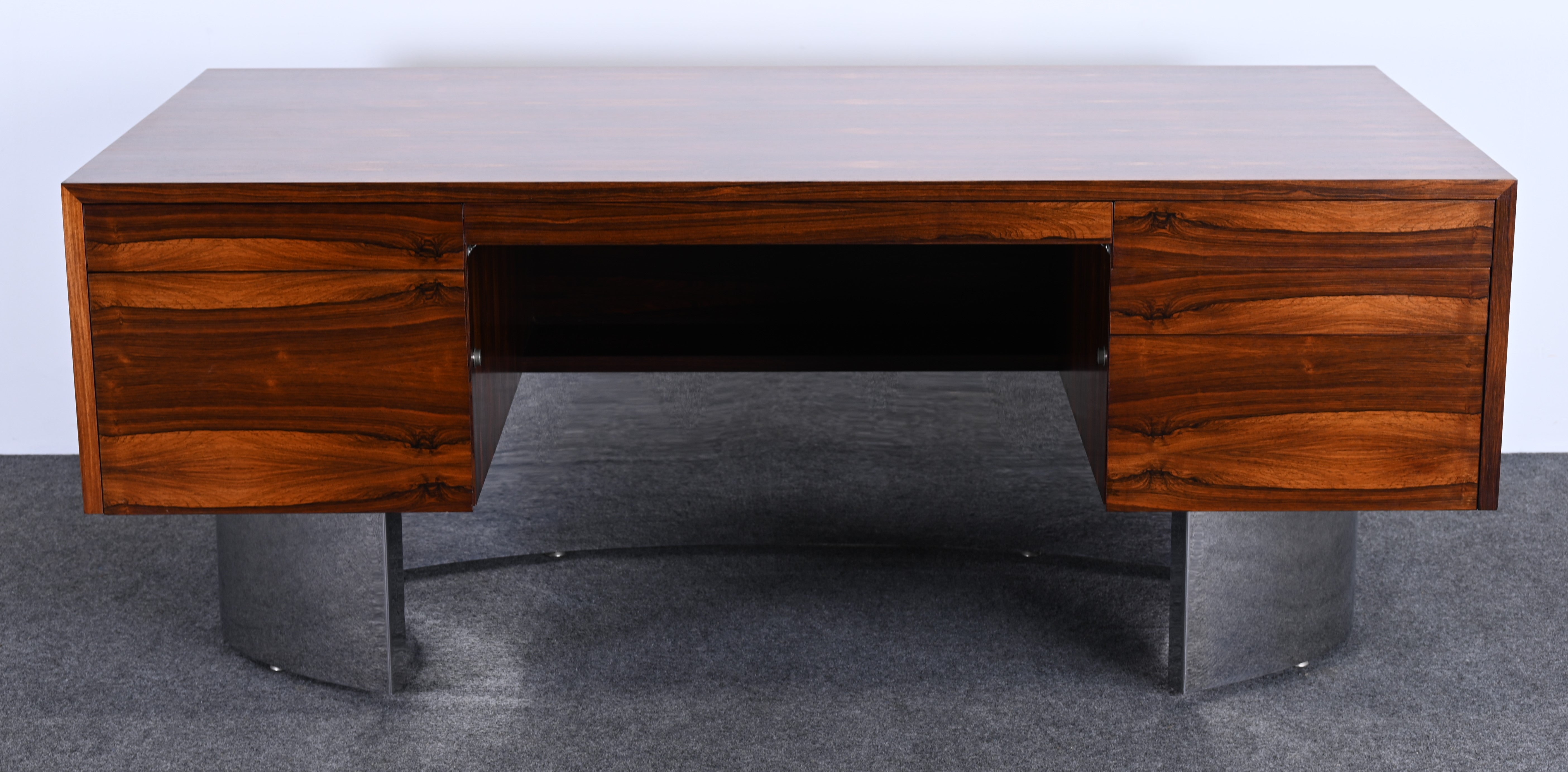 A gorgeous unique Danish rosewood and stainless steel executive desk circa 1960s. This amazing desk came from a third-generation office of a large corporation in Pennsylvania. The office was furnished with other stainless steel and rosewood