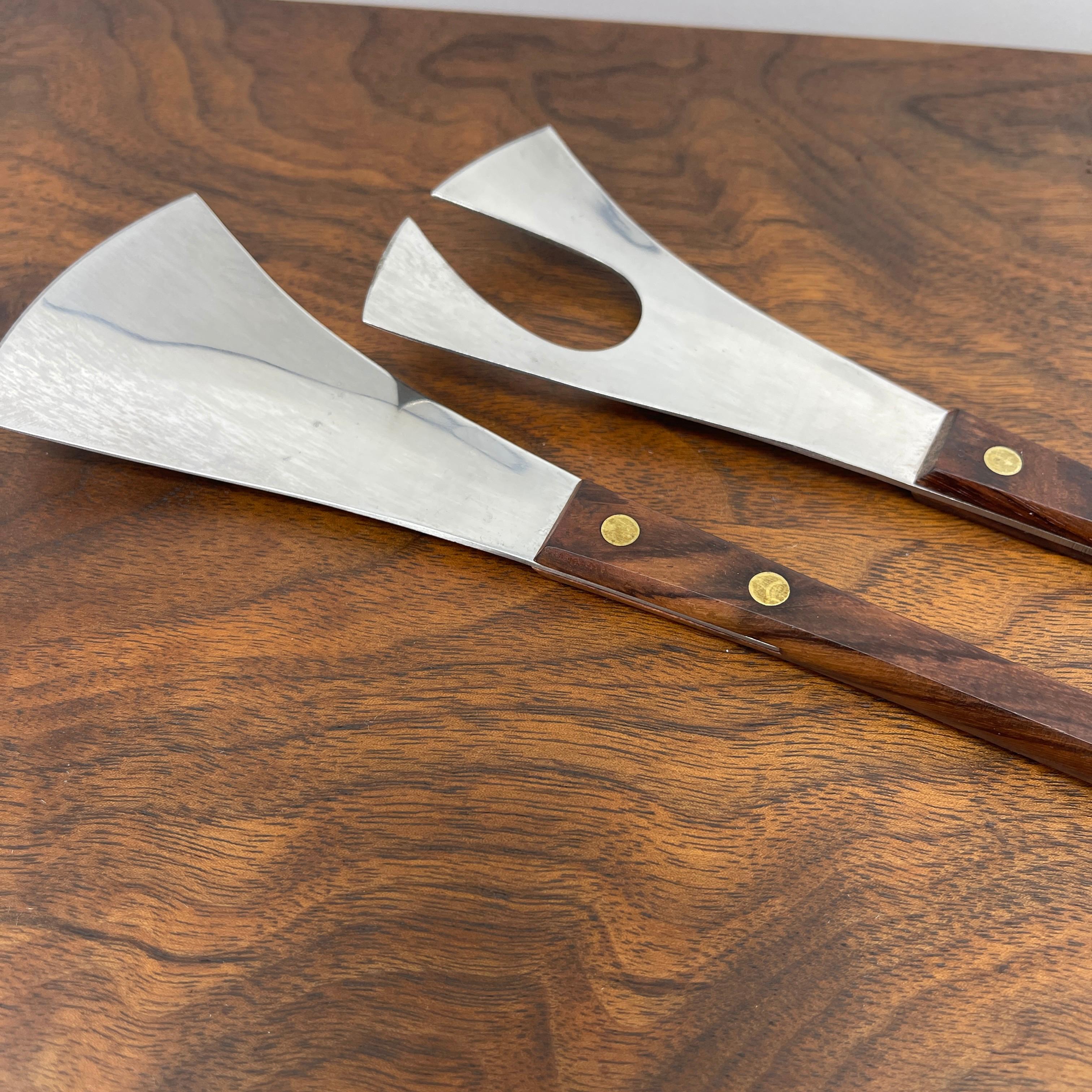 Mid-Century Modern rosewood and stainless steel salad tong set.
Made in Denmark, this slender, elegant pair of tongs will grace your table either serving salad or pasta. Classic Danish design, the wood is warm; beautiful and functional set for