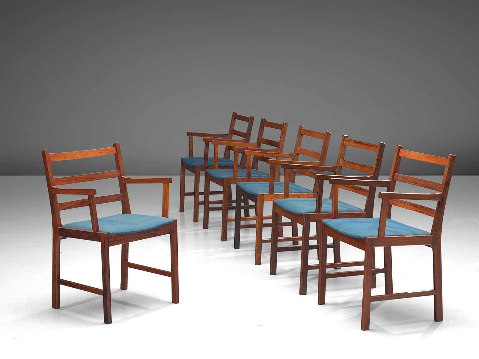 Set of six armchairs, rosewood and blue wool, Denmark, 1960s.

This set of rosewood chairs have a warm grained frame. The chairs are built up of a slatted back with three slats and a Minimalist, clean frame. The warm color of the wood combines great