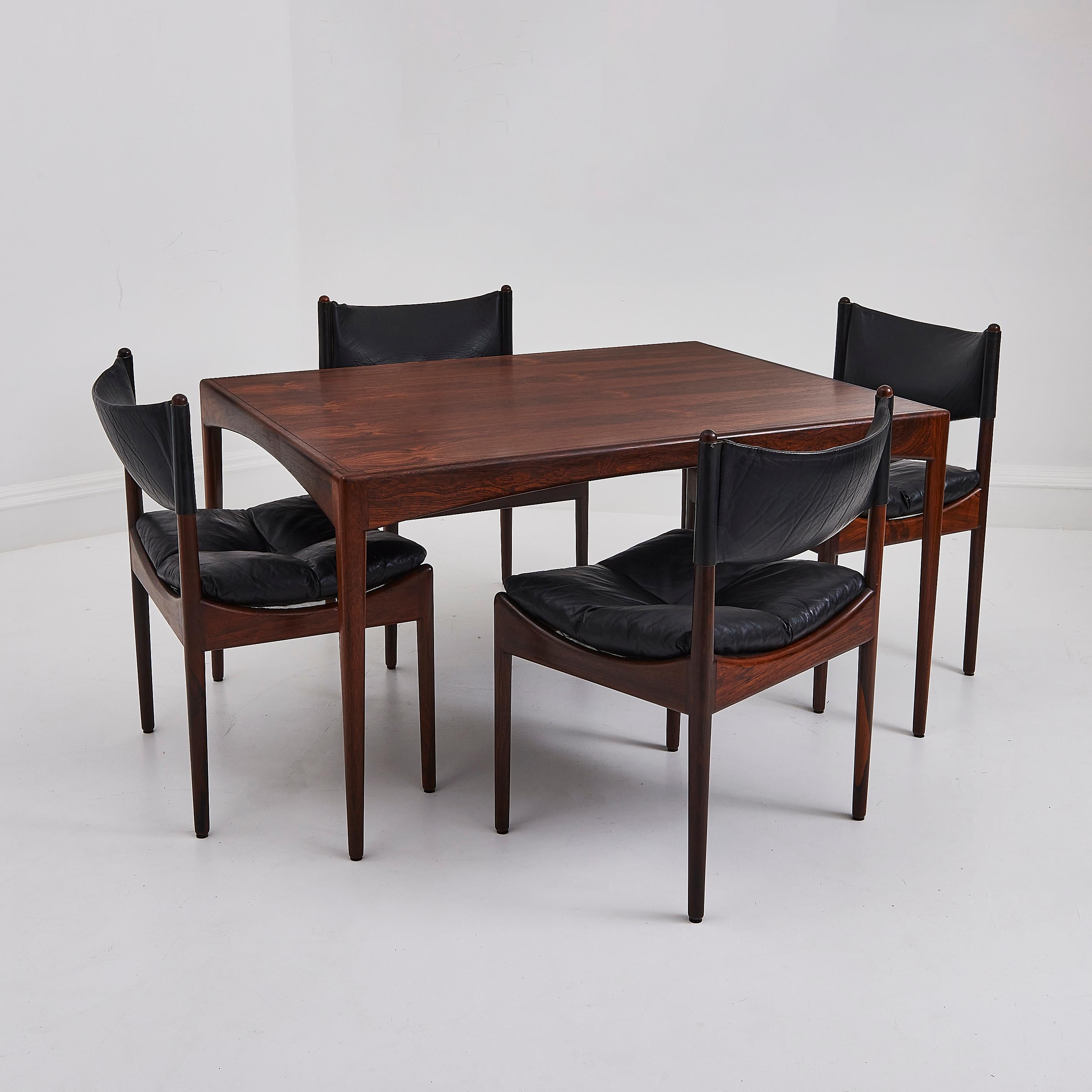 An exquisite dining set, designed by renowned Danish designer Kristian Solmer Vedel c. 1960 showcases mid-century Scandinavian craftsmanship. Manufactured by Søren Willadsen, the set includes a rosewood dining table and four chairs upholstered in