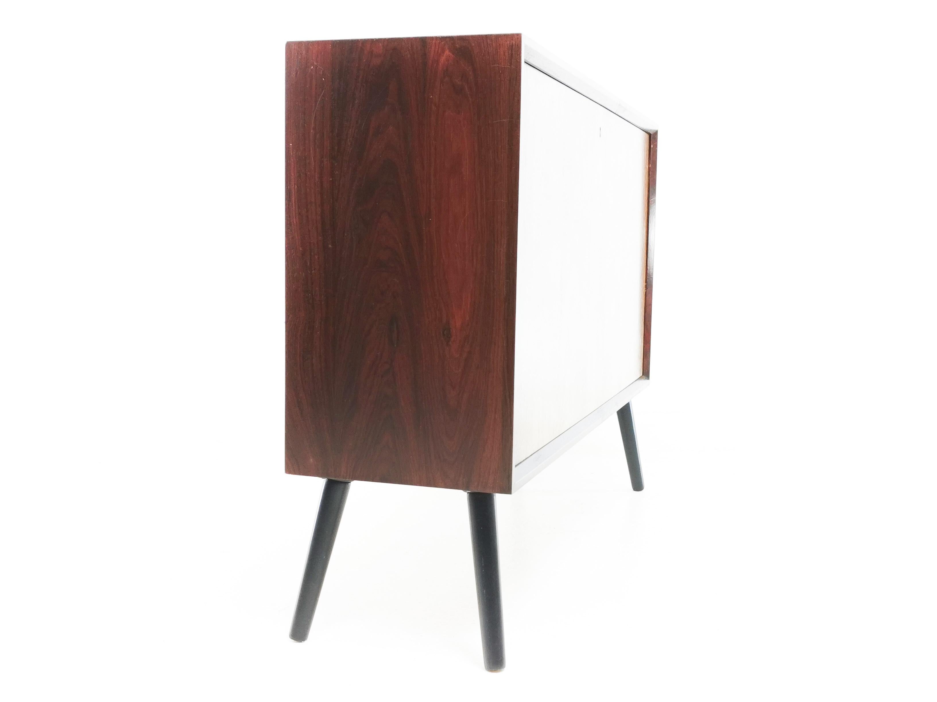 Danish rosewood cabinet

A beautifully designed and crafted cabinet by Johannes Sorth for Bornholm Møbelfabrik. 

The unit has minimal clean lines, it is raised on splayed ebonised legs and features a single fall front cupboard door with key.