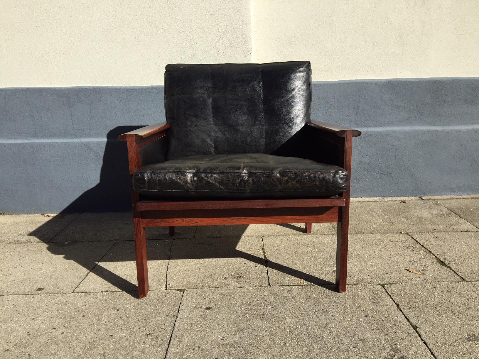 This lounge chair No. 4 or the Capella chair was designed by Illum Wikkelsø in 1959 and manufactured by Niels Erik Eilersen in the early 1960s. It features original black leather upholstery and solid rosewood frame, seat and armrests. Please notice