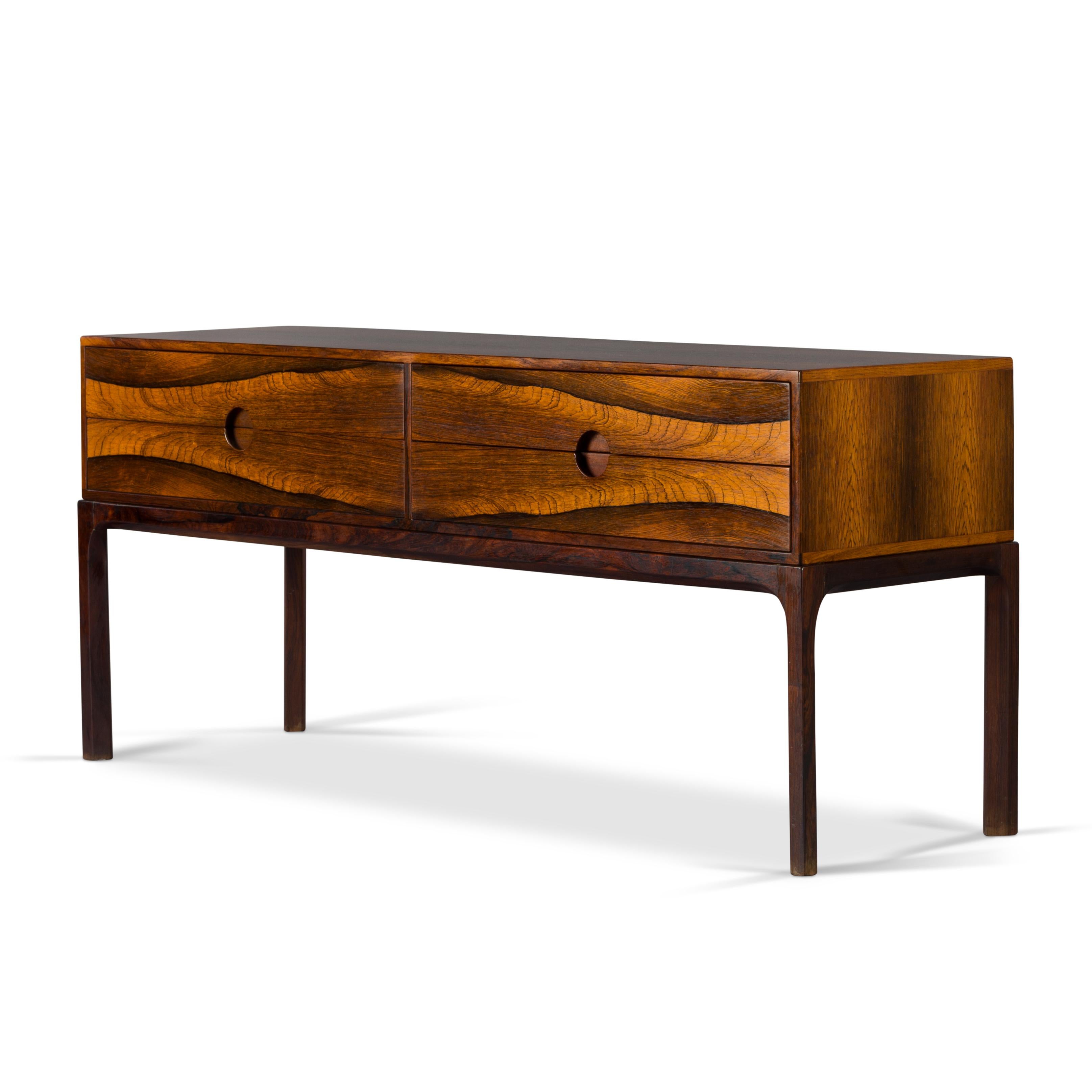 Beautiful small commode or chest with four drawers, design no. 394 by Aksel Kjersgaard. The print in the rosewood is magnificent! Symmetrical en expressive. This piece is in very good vintage condition. An eye-catcher in your interior. The legs are