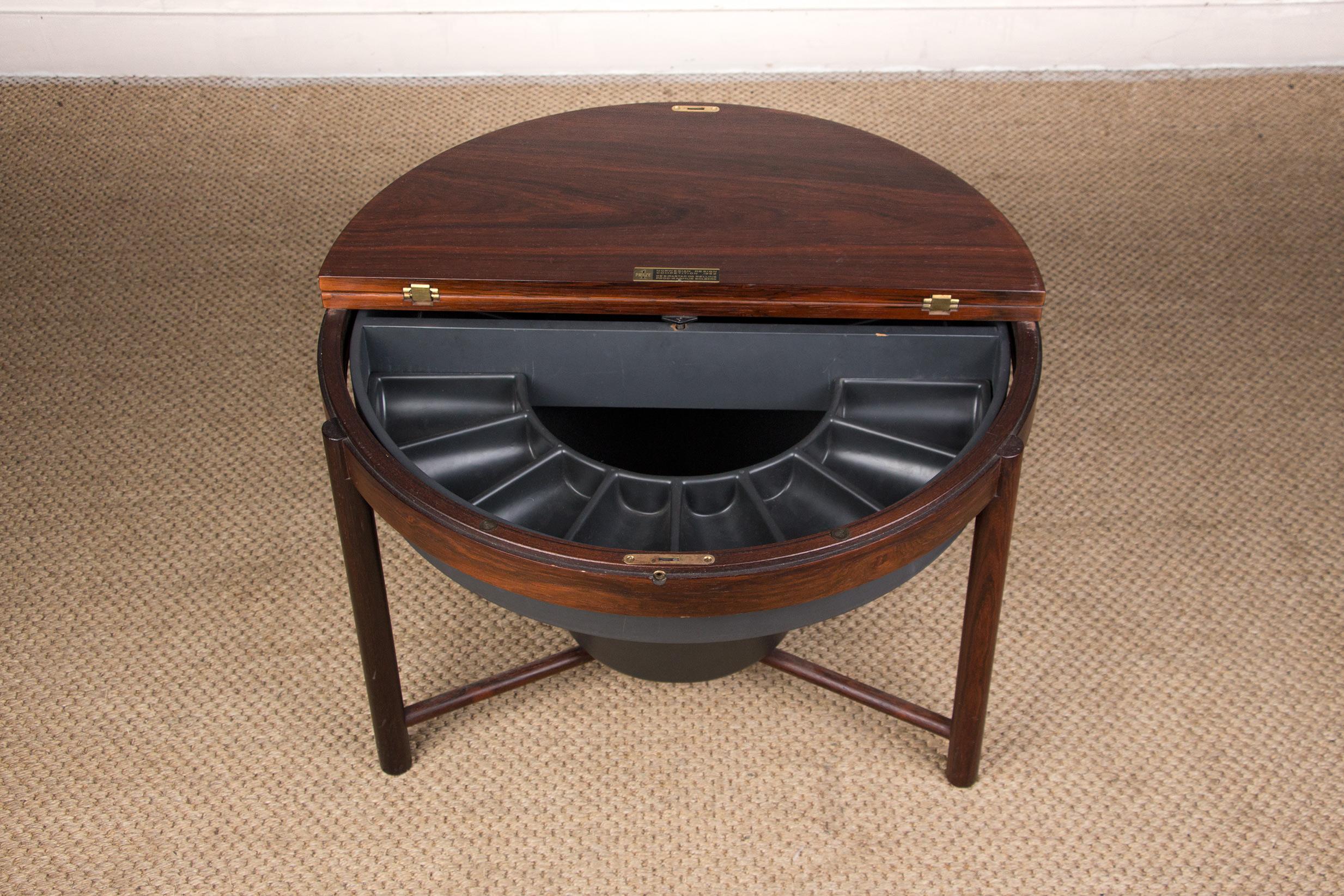Superb Scandinavian bar cabinet that can be used as a coffee table. Consisting of a circular tray, half of which lifts up and opens onto a rotating box that can accommodate bottles and glasses. This particularly original and ingenious system, first