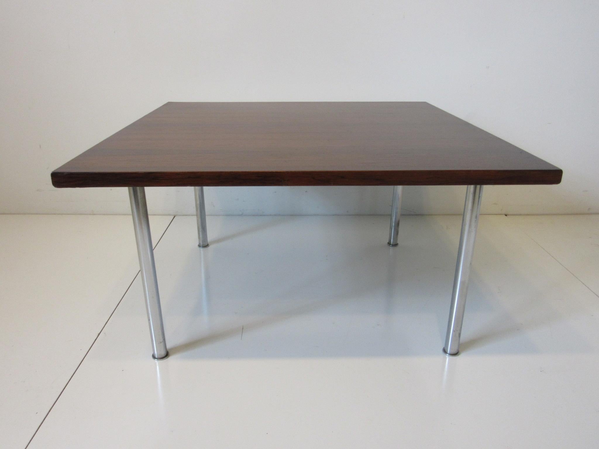 A rich and well grained dark Brazilian rosewood square coffee table with chromed nickeled legs . Retains the original manufactures label designed by Bodil Kjaer for E. Pedersen and Sons a/s made in Denmark.