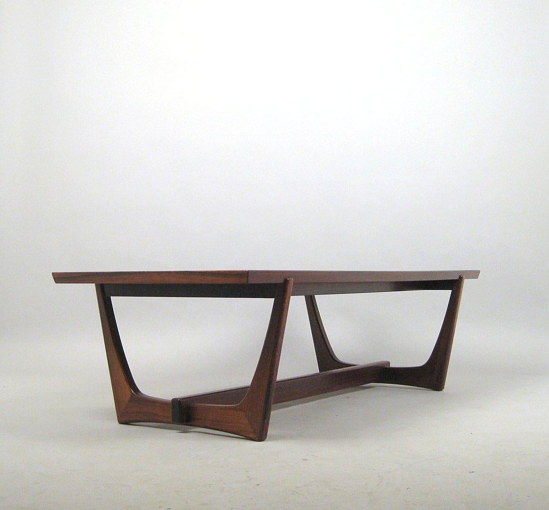 Danish designed or manufactured rosewood coffee table with bent frame legs that replicate the rib structure of a ship's hull. Construction with frame in solid, dark wood with a strong grain, veneered top.