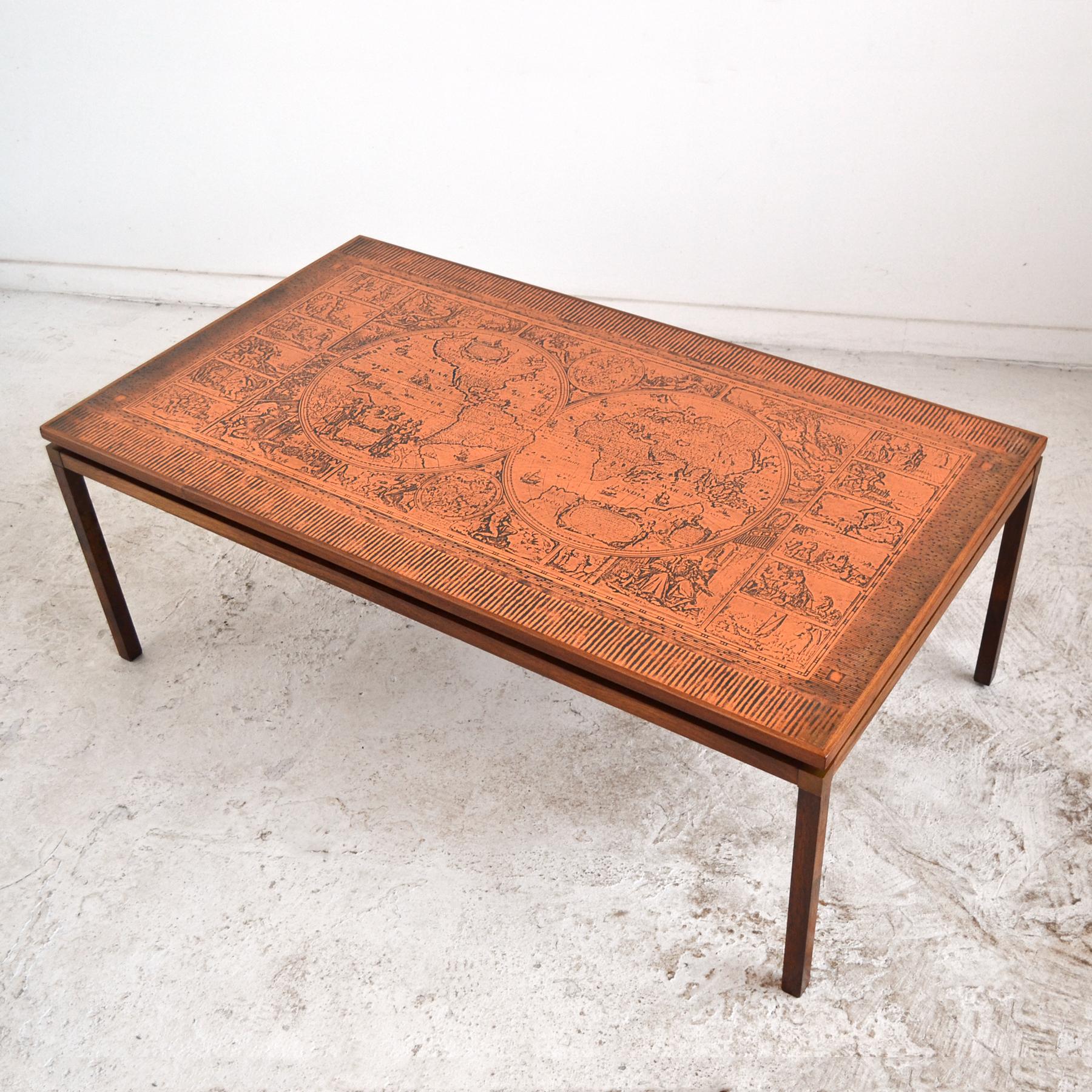 This compelling and uncommon large coffee table has a very subtle form and construction details. The rosewood base supports a copper covered top with etched antique global map imagery.