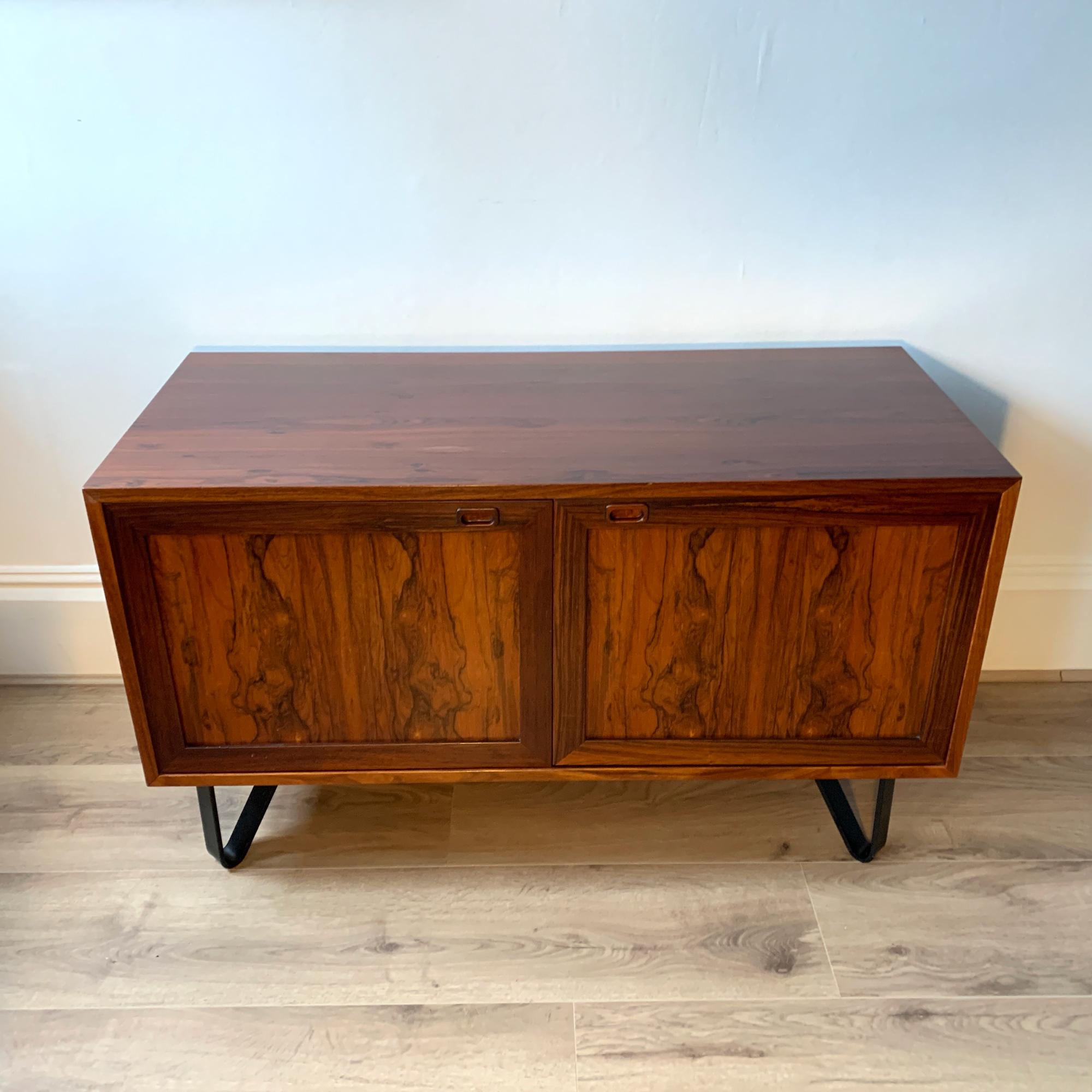 High-quality Danish Rosewood Sideboard from the 1970s and manufactured by Sejling Skabe. Featuring two cupboard doors with recessed door pulls, and internal shelving.

The unit sits on hairpin legs. Dimensions: W:110 x D:48 x H:66 cm

Condition:
