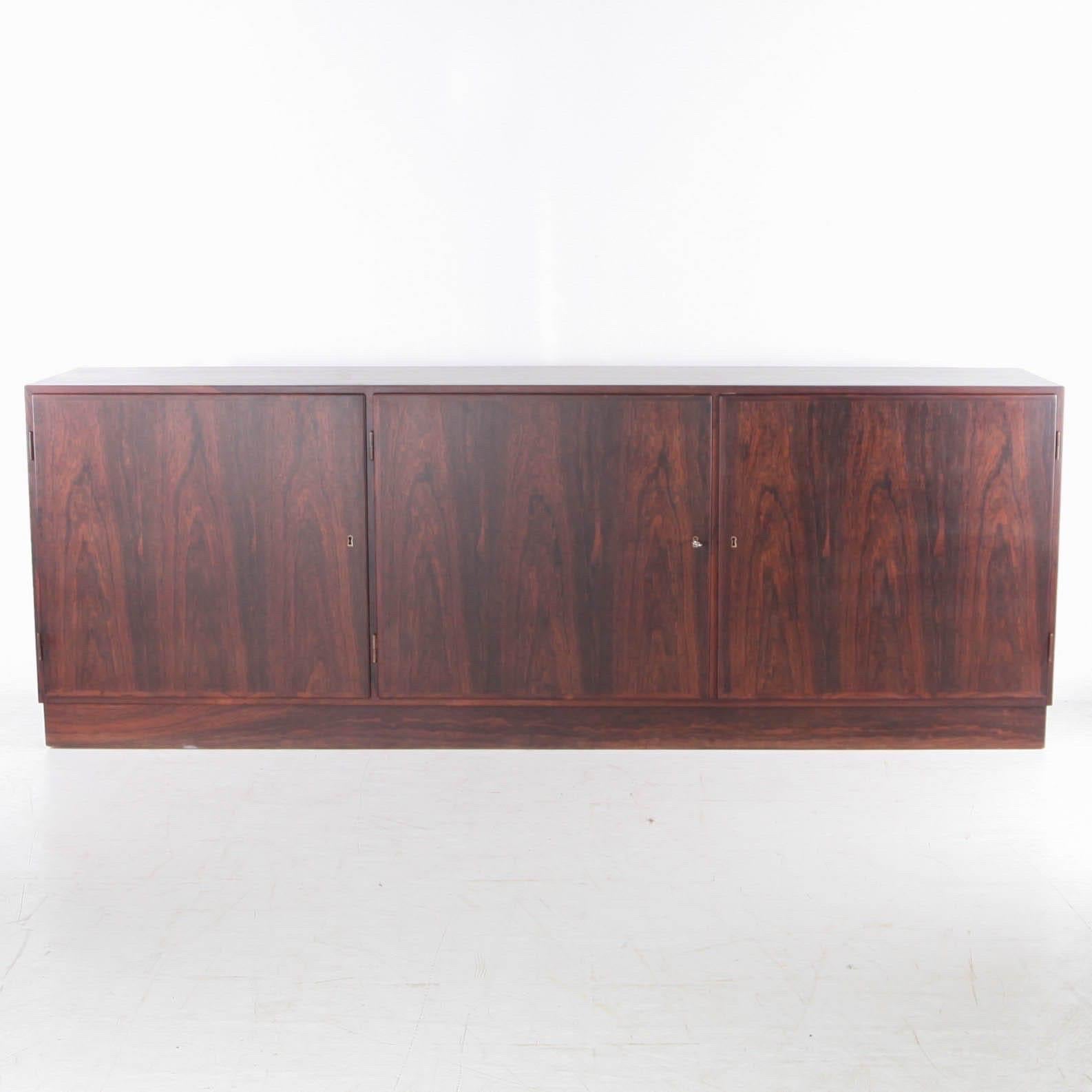 Bellissima credenza danese a 3 ante in palissandro degli anni '60.
6 ripiani, una chiave.
Ottima qualità e condizione.
