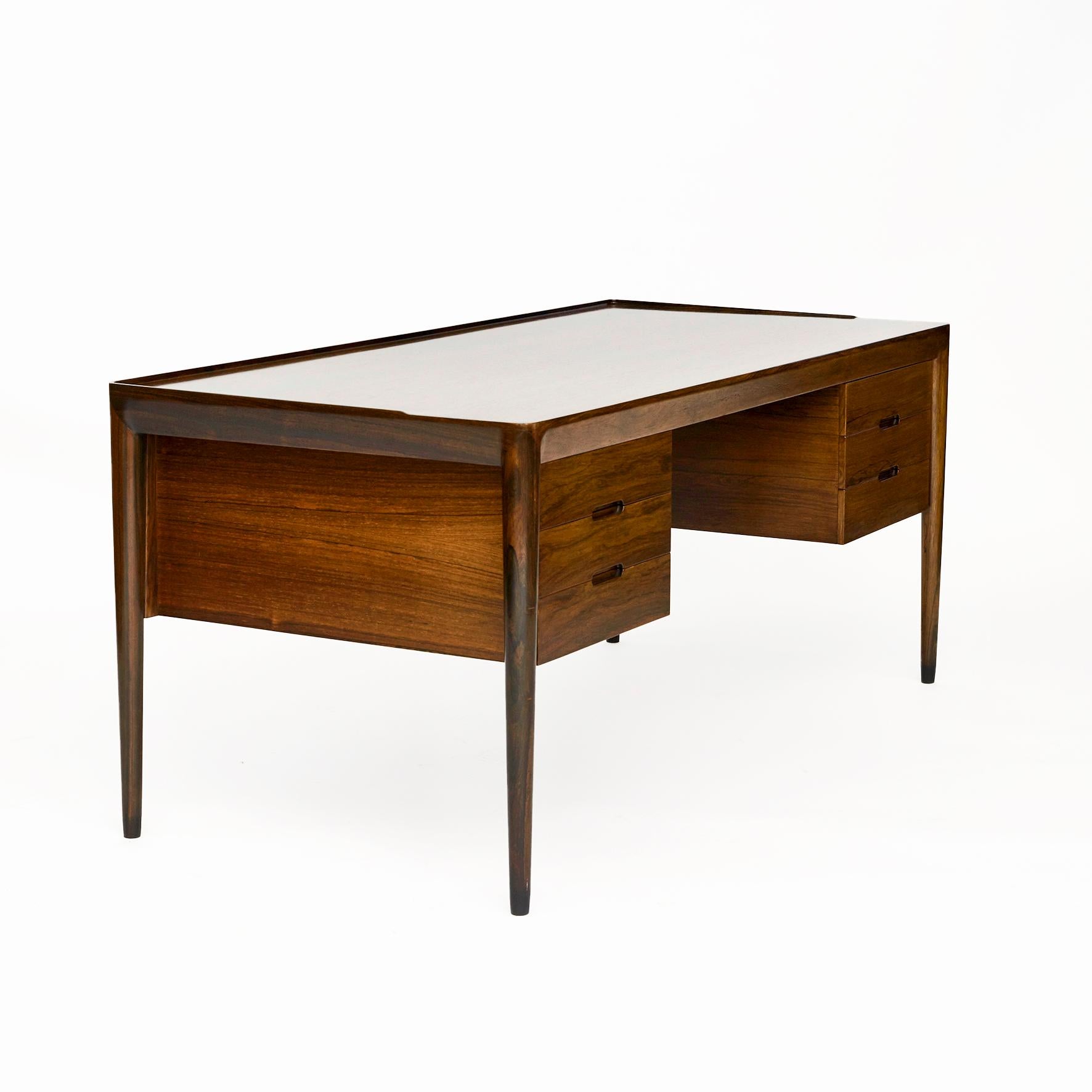 Erik Riisager Hansen.
Freestanding desk in Rio rosewood. Top with raised edge on tapered legs. Three drawers at front with recessed pulls
The desk shows remarkable high-quality craftsmanship and is equipped with many beautiful details.
Executed by
