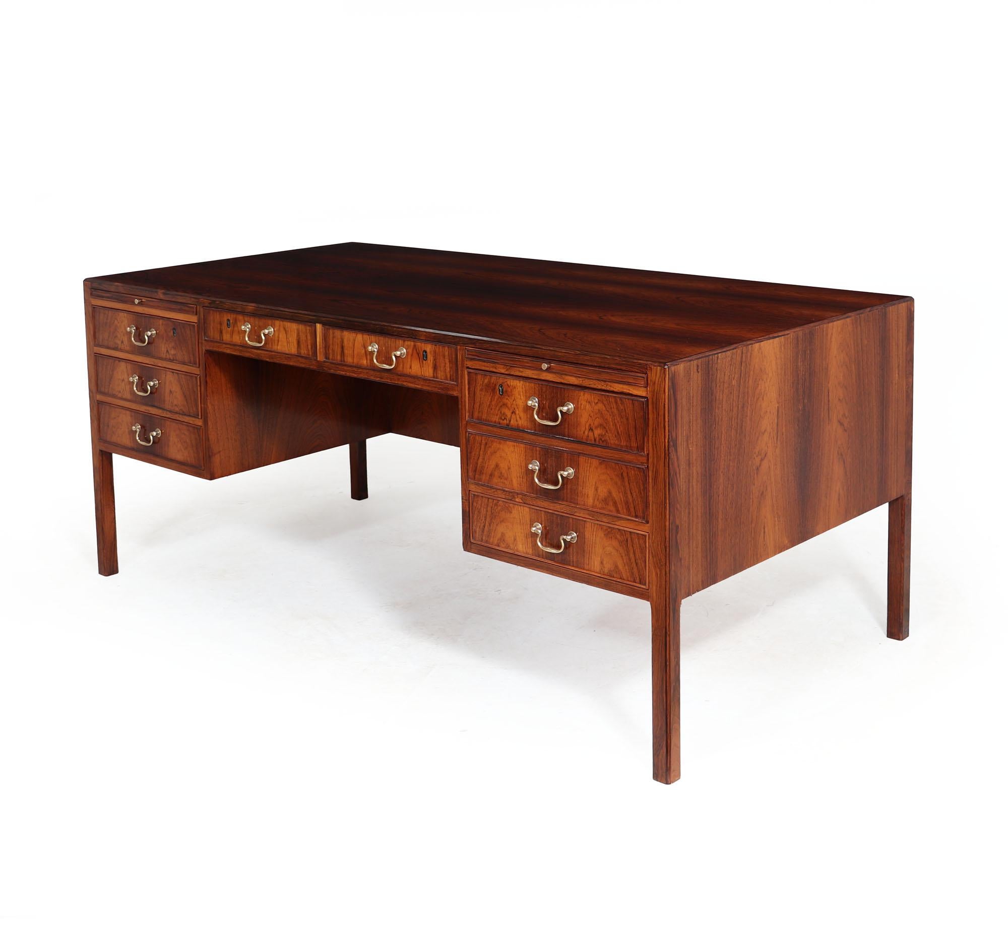 A midcentury desk danish produced with eight drawers to the front and slides above all with swan neck handles two cupboards and two further lockable drawers to the back Fully handmade with handcut precision dovetail joint solid rosewood legs -