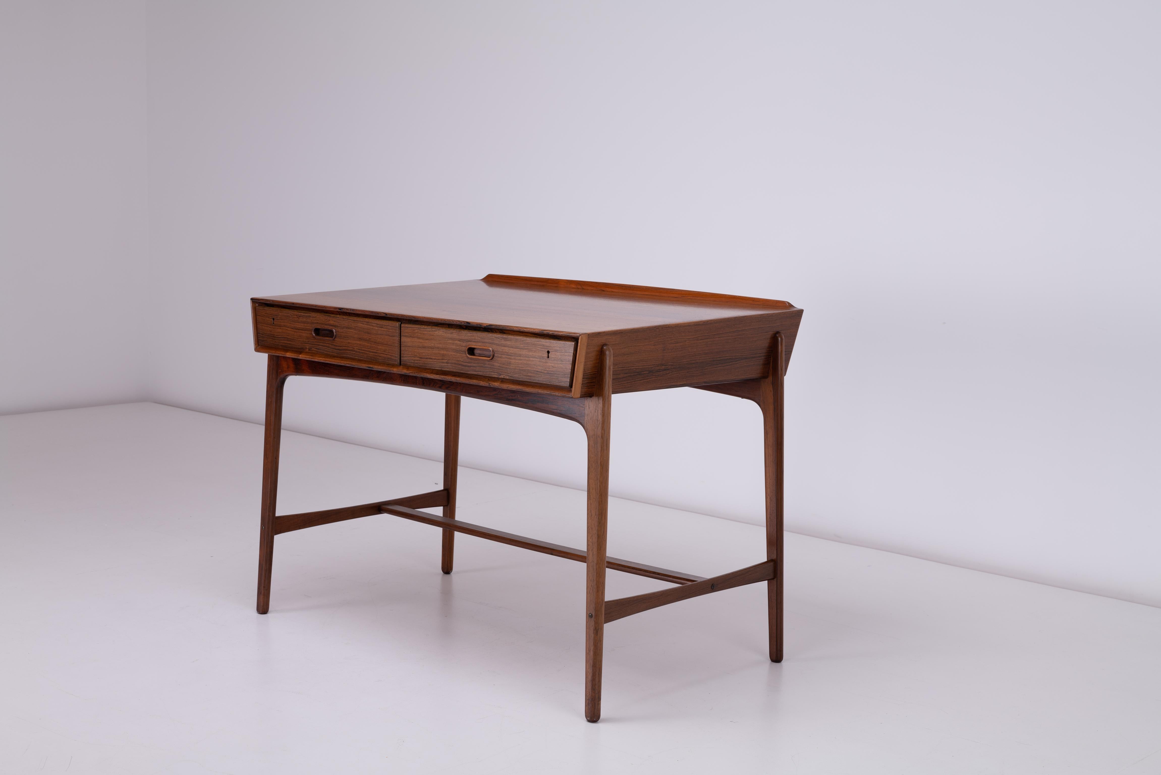 Nous avons à vendre une très élégante table à écrire en bois de rose par Svend Aage Madsen pour Sigurd Hansen vers 1958. Il s'agit d'une très belle pièce, très bien réalisée. La pièce a été conçue à l'origine comme table d'écriture, elle est