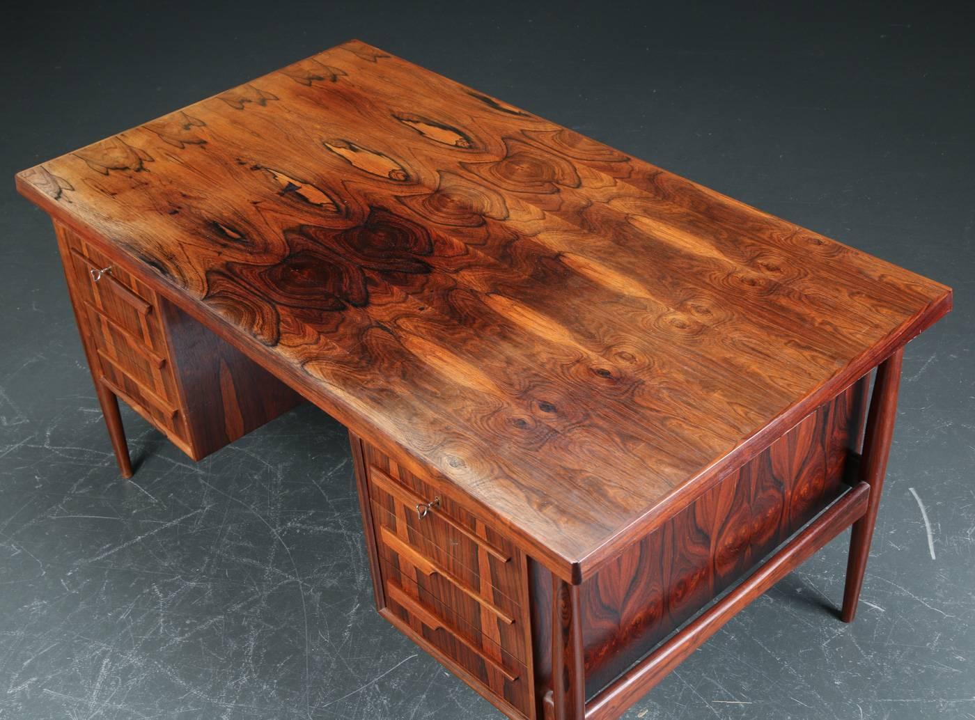 The dramatic rosewood color and figure of this desk is exceptional. Measuring H 72cm x L 172cm x D 82cm, this desk has three drawers either side and two cabinets at rear. Made during the 1960s in Denmark.

At buyer's request, the desk top can be