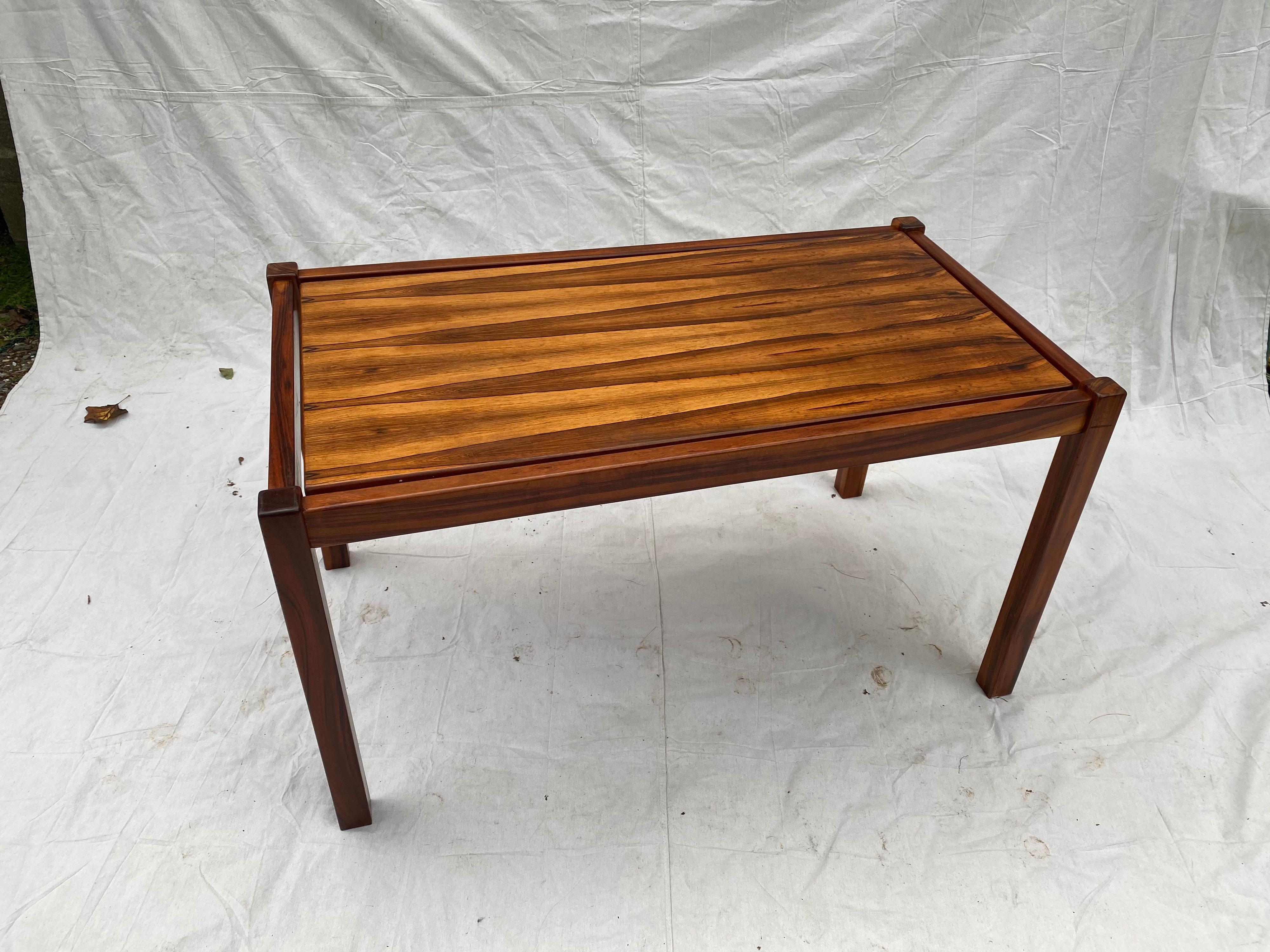 Danish rosewood desk/ table. Solid rosewood frame supports a floating rectangular top. Very impressive grain on top of table. 4 tabs hold the insert in place. Table breaks down for ease of transporting!