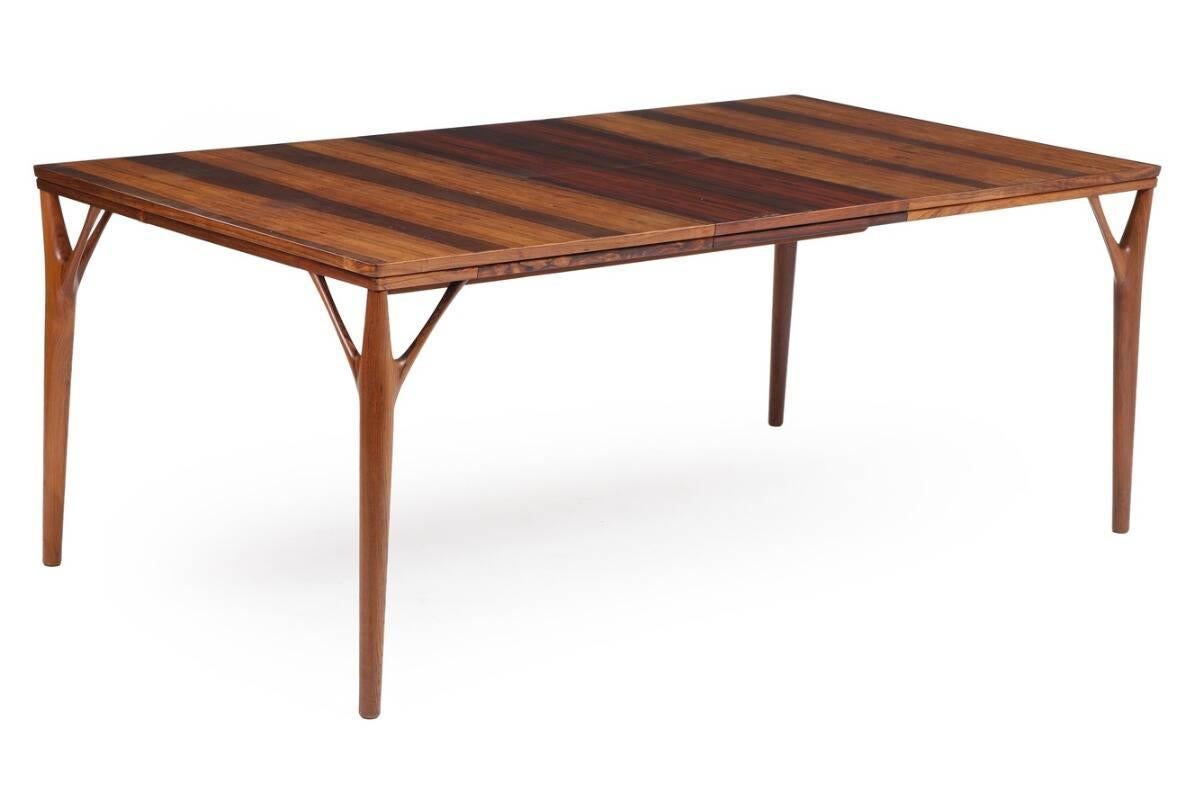 Rectangular rosewood dining table with underlying foldable extra leaf. Manufactured and marked c1950s by H. Sigh & Søns Møbelfabrik. Measures: H 72.5, L 140/187., W 100 cm. 

The design of this table has been attributed to Helge Vestergaard Jensen