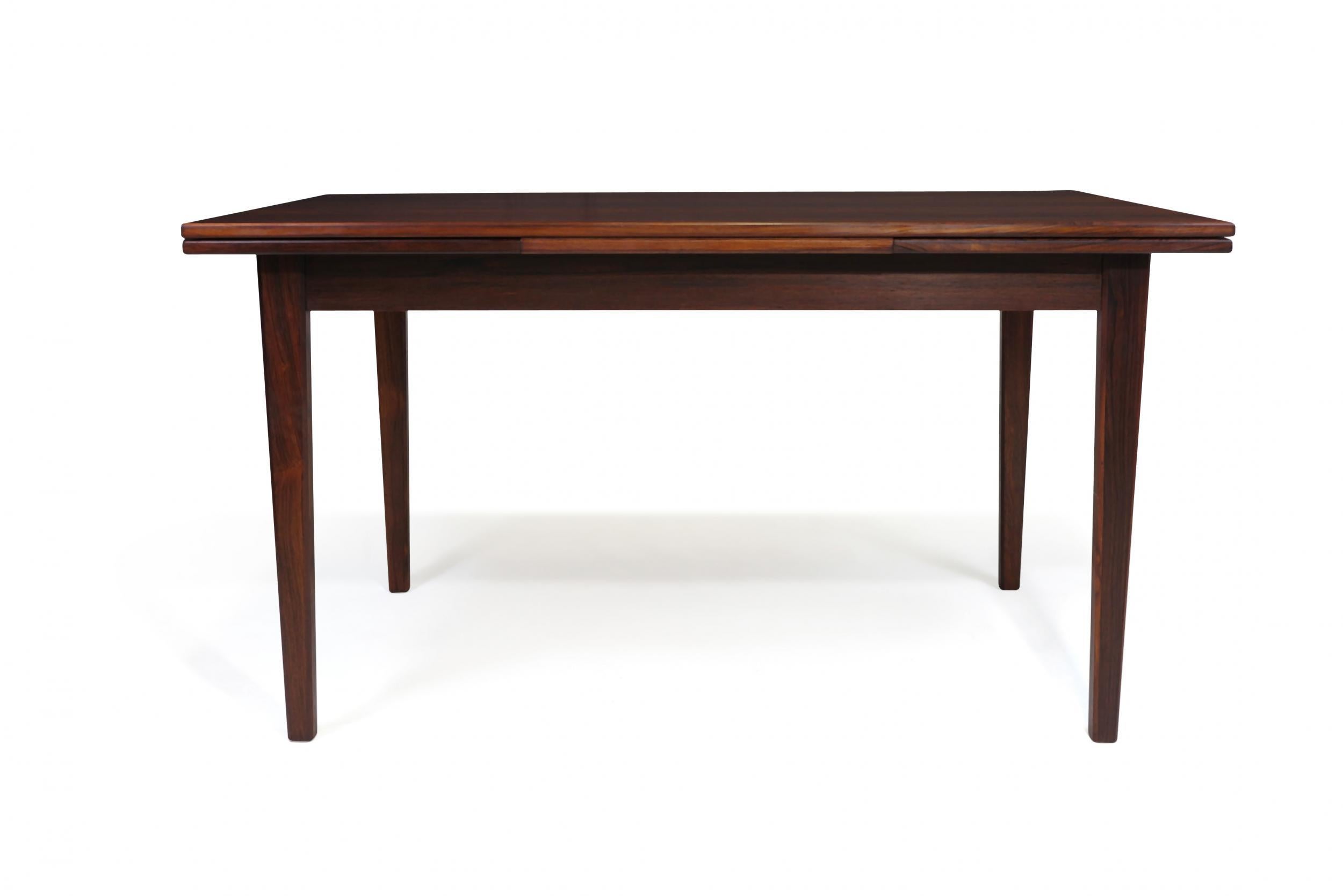 Midcentury Brazilian rosewood dining table with draw-leaves manufactured in Denmark circa 1965. Seats six closed, up to ten guests with pull-out leaves extended. Finely restored in a natural oil finish. 
Total width fully extended with two leaves