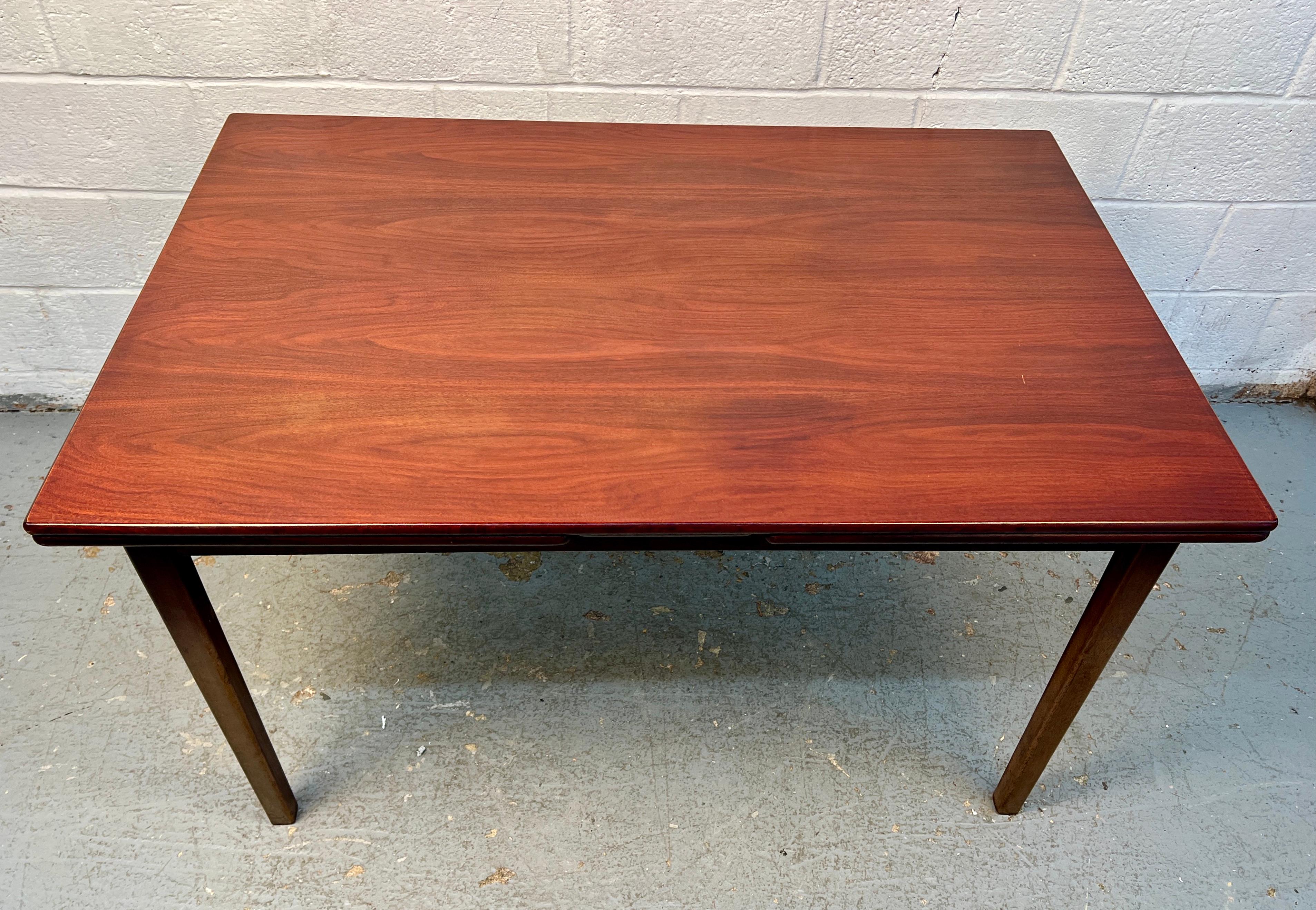 Eccezionale tavolo da pranzo danese della metà del secolo scorso, realizzato in legno di palissandro riccamente scolpito e caratterizzato da un elegante design a foglie allungabili. La forma snella del tavolo e i toni caldi mettono in risalto la