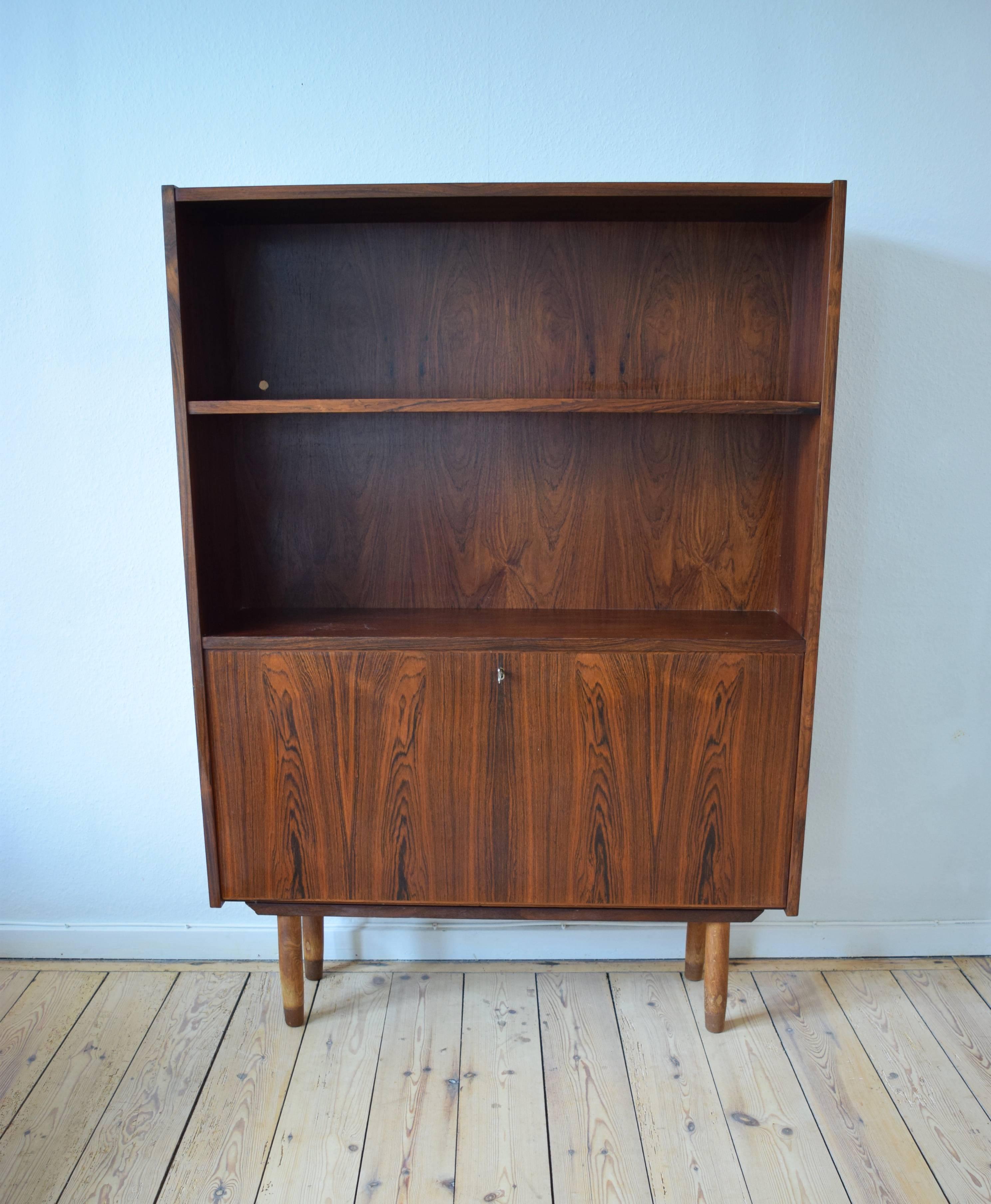 Rosewood drinks cabinet/bookshelf manufactured in Denmark in the 1960's by Viby Møbelfabrik. Features one adjustable shelf, and a drinks cabinet with pull down door, and sits on a frame base with oak & teak legs. Some ducting holes in the back