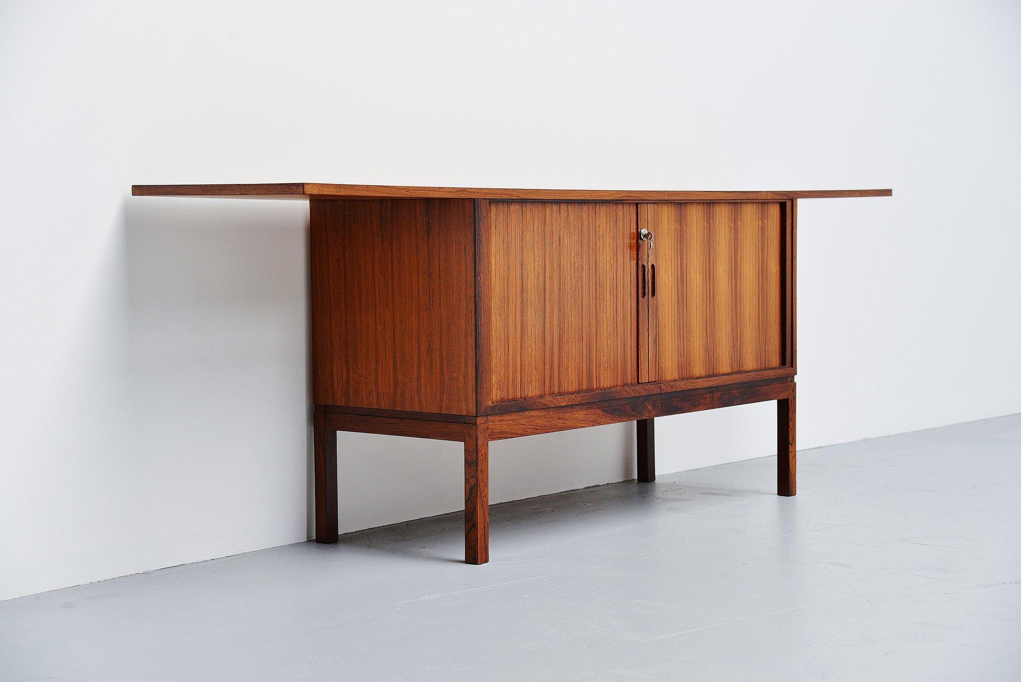 Very nicely and unusual shaped rosewood dry bar cabinet made by unknown designer or manufacturer, Denmark, 1960. The dry bar has very nice tambour doors with storage space for bottles and glasses behind. The bar has a very nice rosewood grained