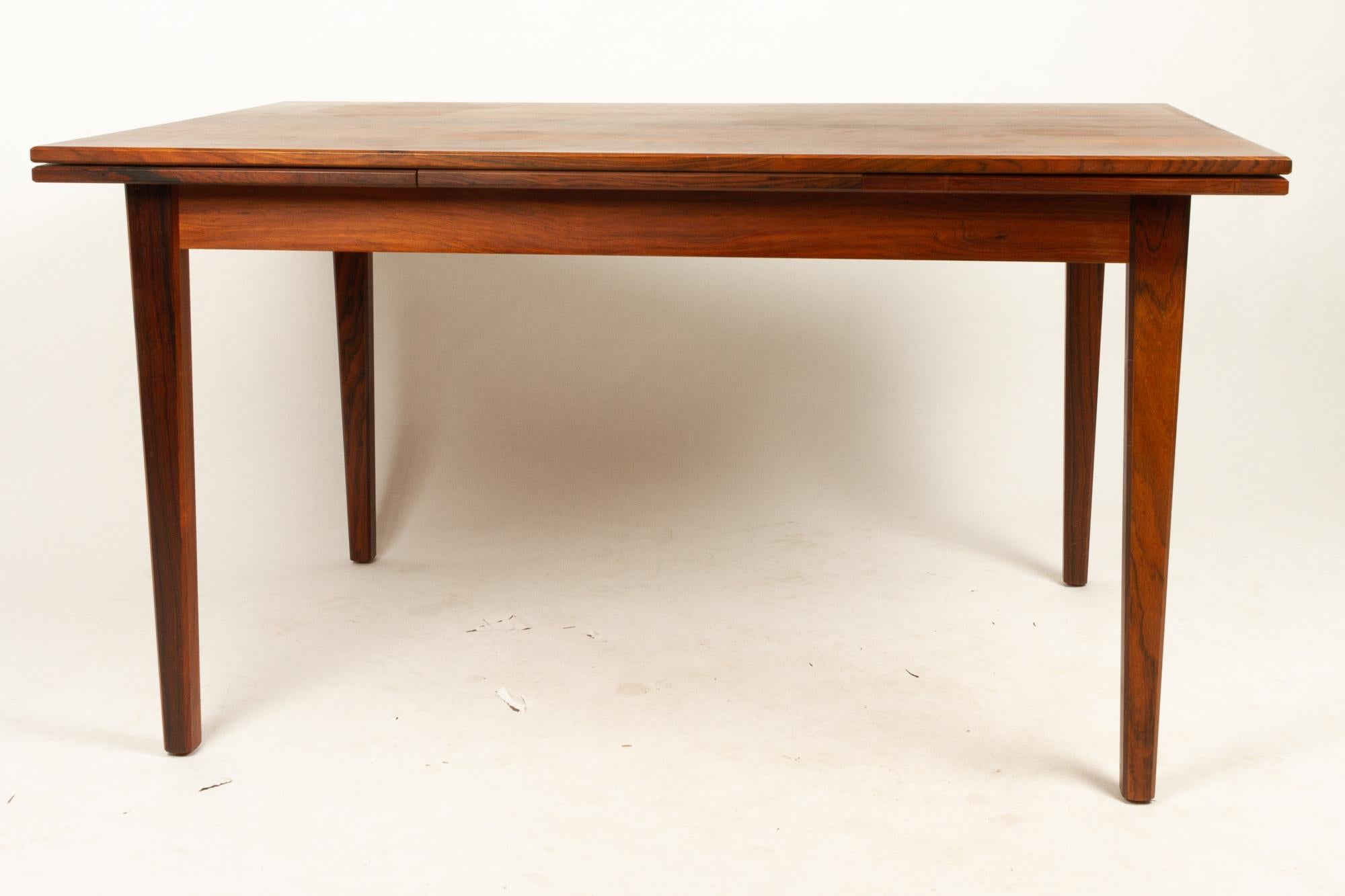 Danish rosewood extendable dining table, 1960s.
Mid-Century Modern dining table with hidden extension leaves. Leaves pulls out from the ends of the table. Square tapered legs.
Extended total length: 227.5cm. Original makers label on the