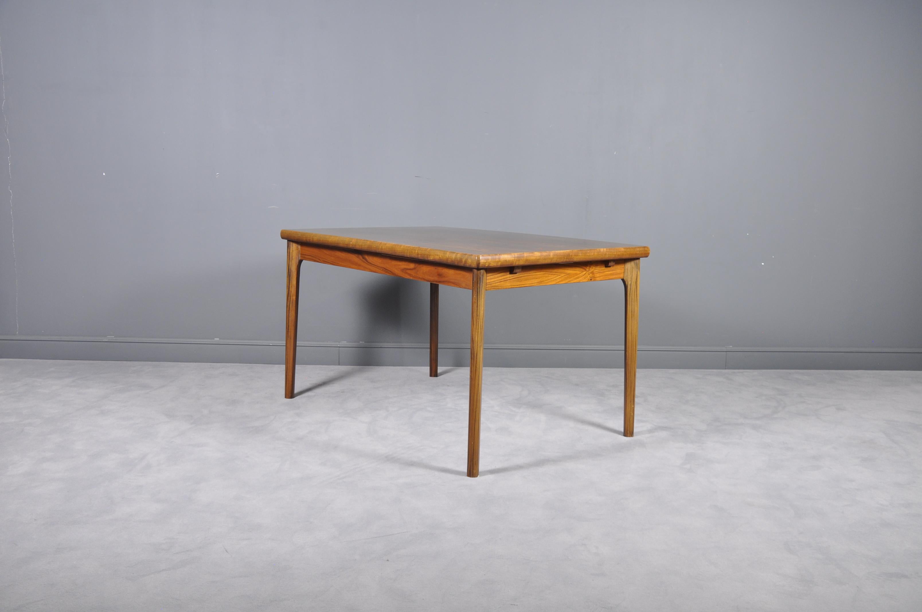 Dining table in teak with extensions designed by Henning Kjærnulf and manufactured by Vejle chairs and furniture factory in the 1960s.

Length of the table fully opened with the two ends leaves is 238 cm.