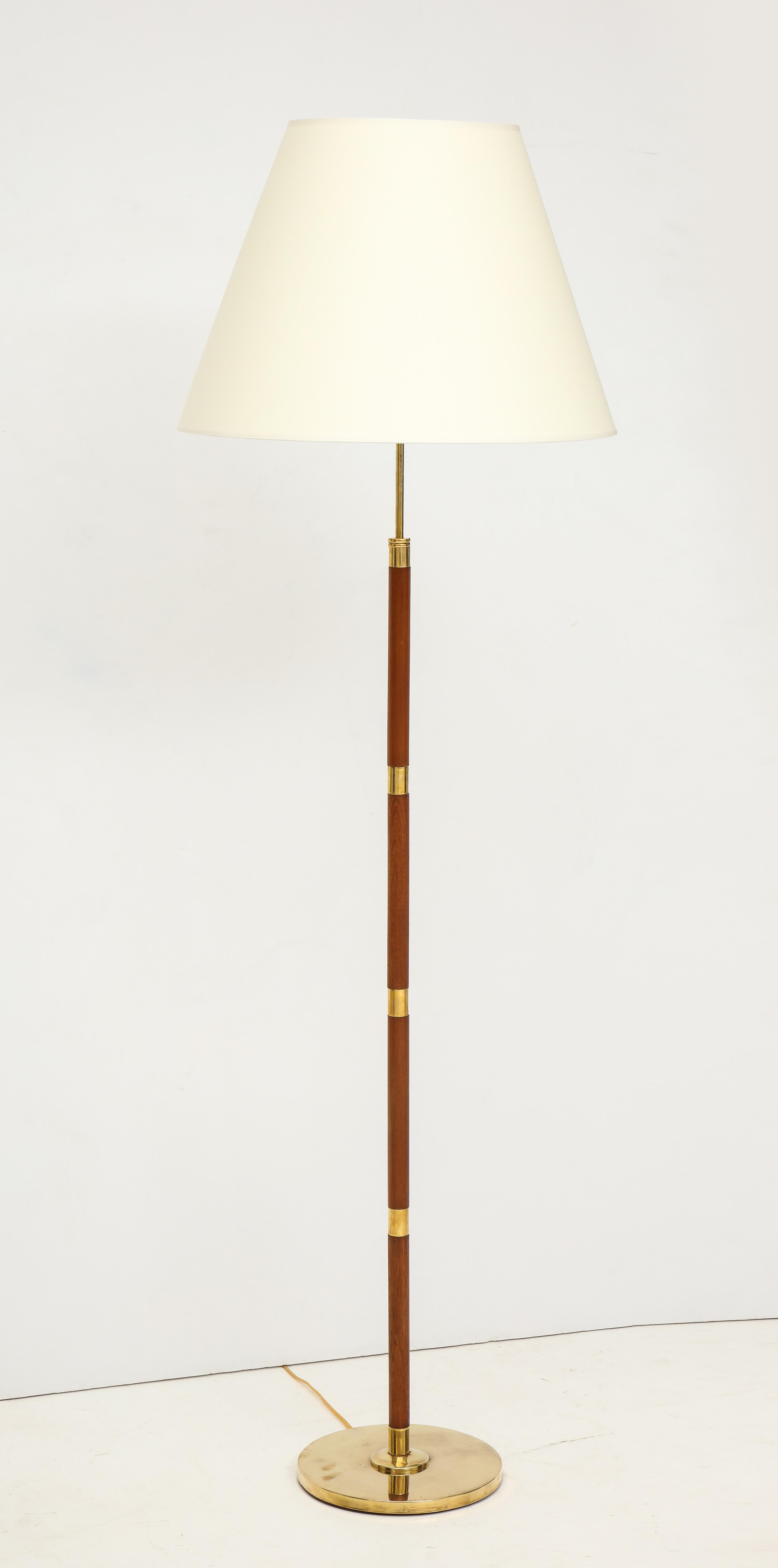 A Danish brass and rosewood floor lamp by Fog & Mørup, circa 1960s. Adjustable height and re-wired for the US. 62in.-69in adjustable height. 19.75in. shade diameter.