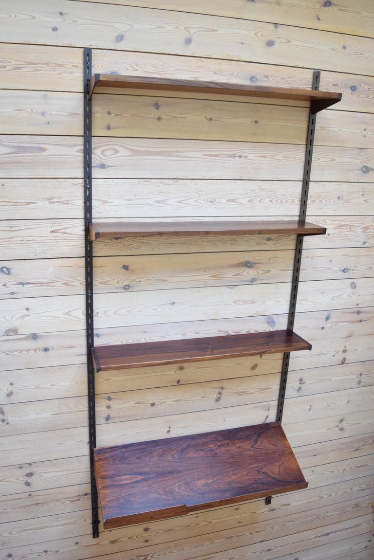 Set of four rosewood shelves designed by Kai Kristiansen and manufactured by FM Møbler, Denmark from the 1960s. This system comprises of three 18cm height adjustable shelves and a magazine shelf, and two hanging rails. We have hanging rails in black