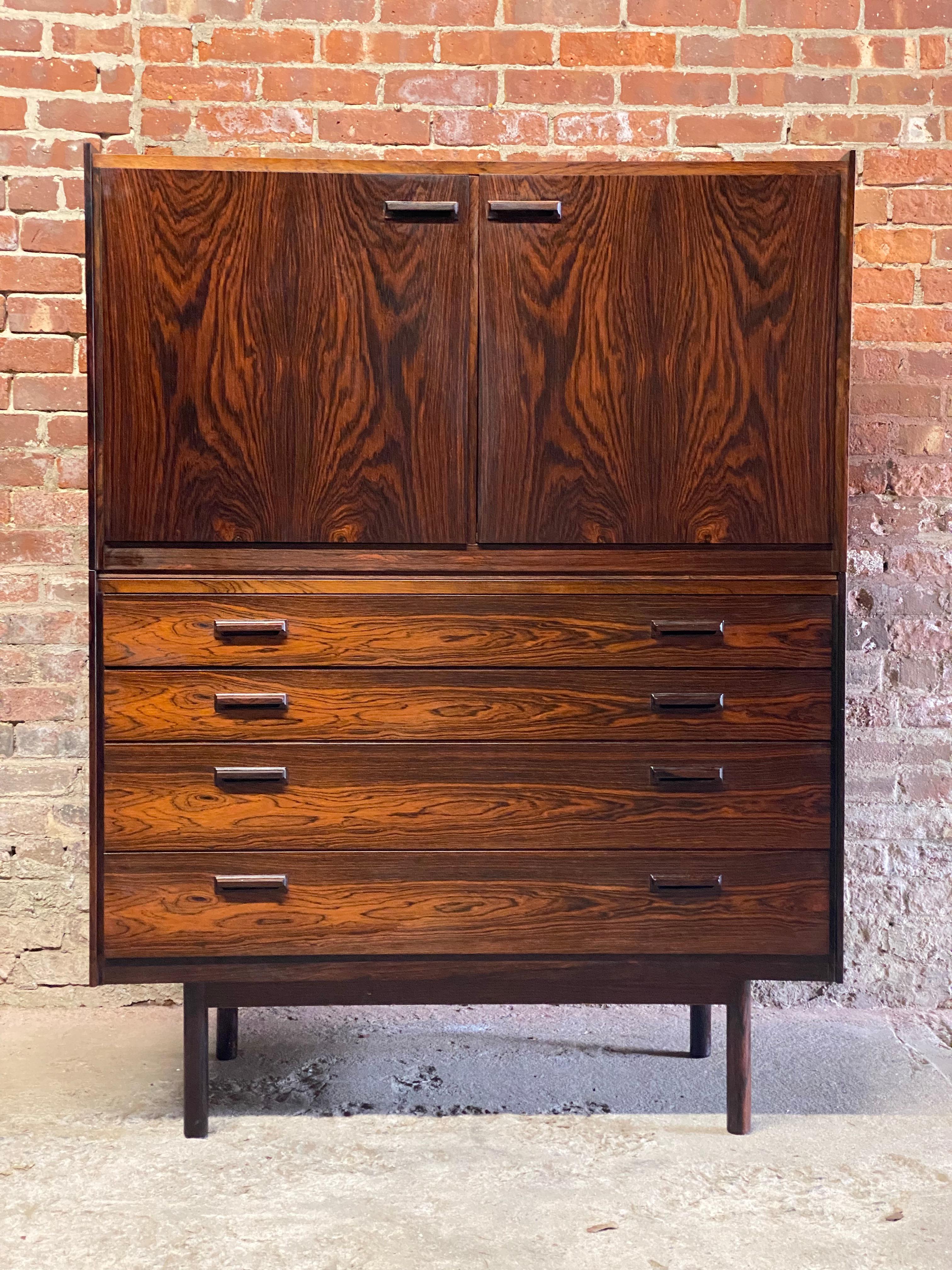 Danish Modern two piece high boy dresser cabinet. Circa 1965. Four deep drawer base on solid dowel legs supporting a two door cabinet with two adjustable shelves and felt lined drawers. Birch or Spruce lined drawers, interior and shelves. Solid