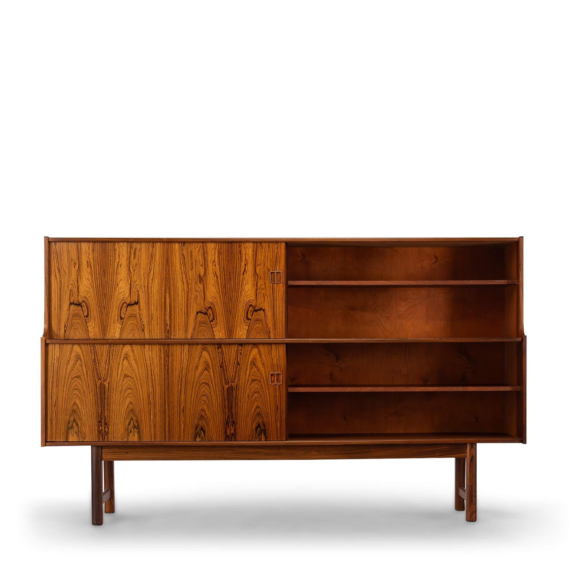 Crédence haute
Cet exquis buffet haut en bois de rose Danish Design est un véritable témoignage de la haute qualité de l'artisanat et de l'élégance intemporelle des meubles scandinaves du milieu du siècle dernier. Placé dans un placage de bois de