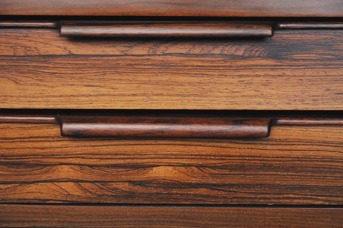 This low sideboard was manufactured in Denmark during the 1960s. It is made from rosewood with attractive and strong grain. The box of this piece has been finished in black. The sideboard has four drawers with original handles from solid wood. This