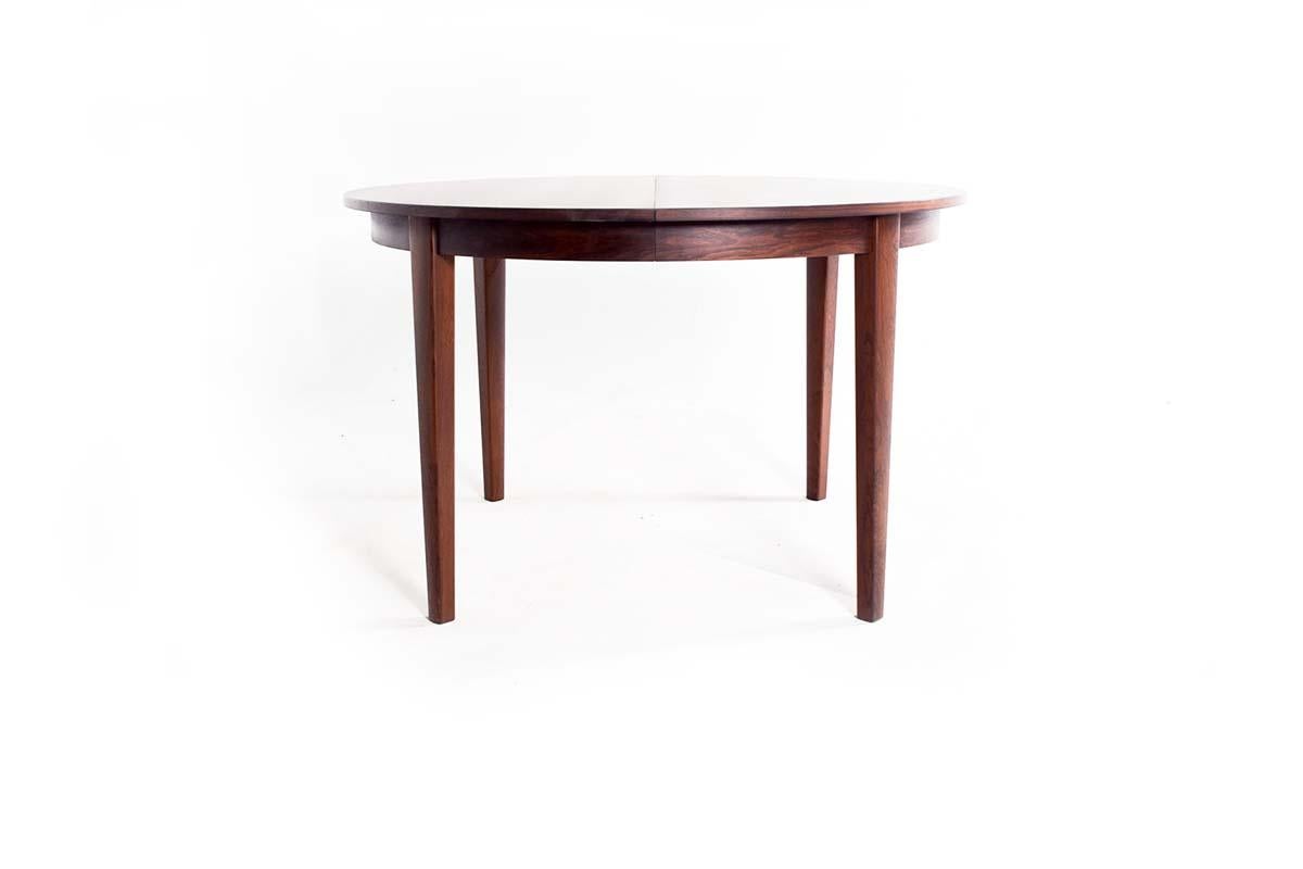 An exemplary rosewood dining table from the 1960s, a period renowned for its exceptional furniture design. This particular table is a large, elegant piece that showcases the strikingly rich grain patterns that rosewood is famous for. When the table