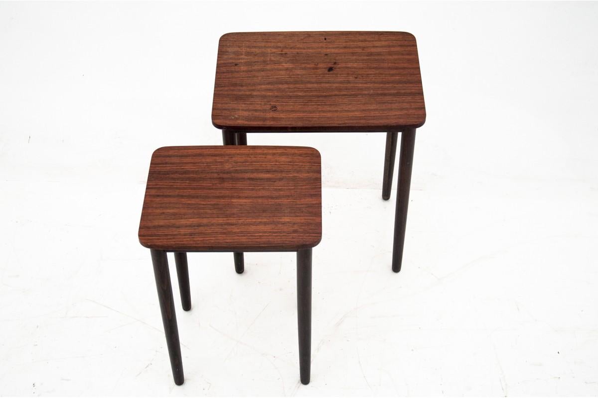 This classic set of two Danish rosewood nesting tables is a beautiful example of mid-century design, combining elegance with functionality. Crafted in Denmark, the tables feature a rich rosewood finish, showcasing the natural grain and deep, warm