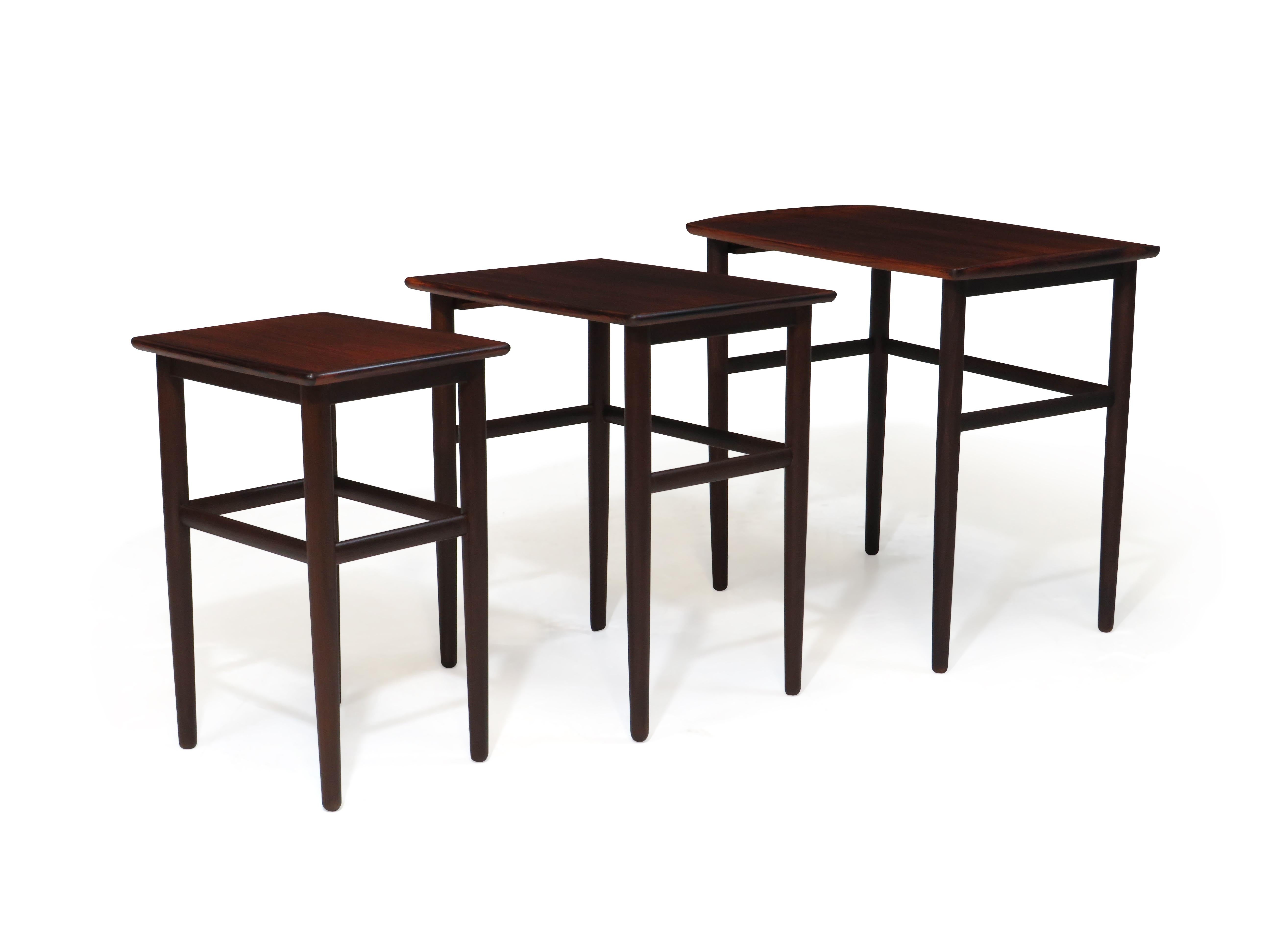 Ensemble de trois tables gigognes en bois de rose avec des pieds coniques et un design minimal. Flexibilité dans toutes les configurations pour répondre à vos besoins. Finement restauré et en excellent état avec des signes mineurs d'âge et