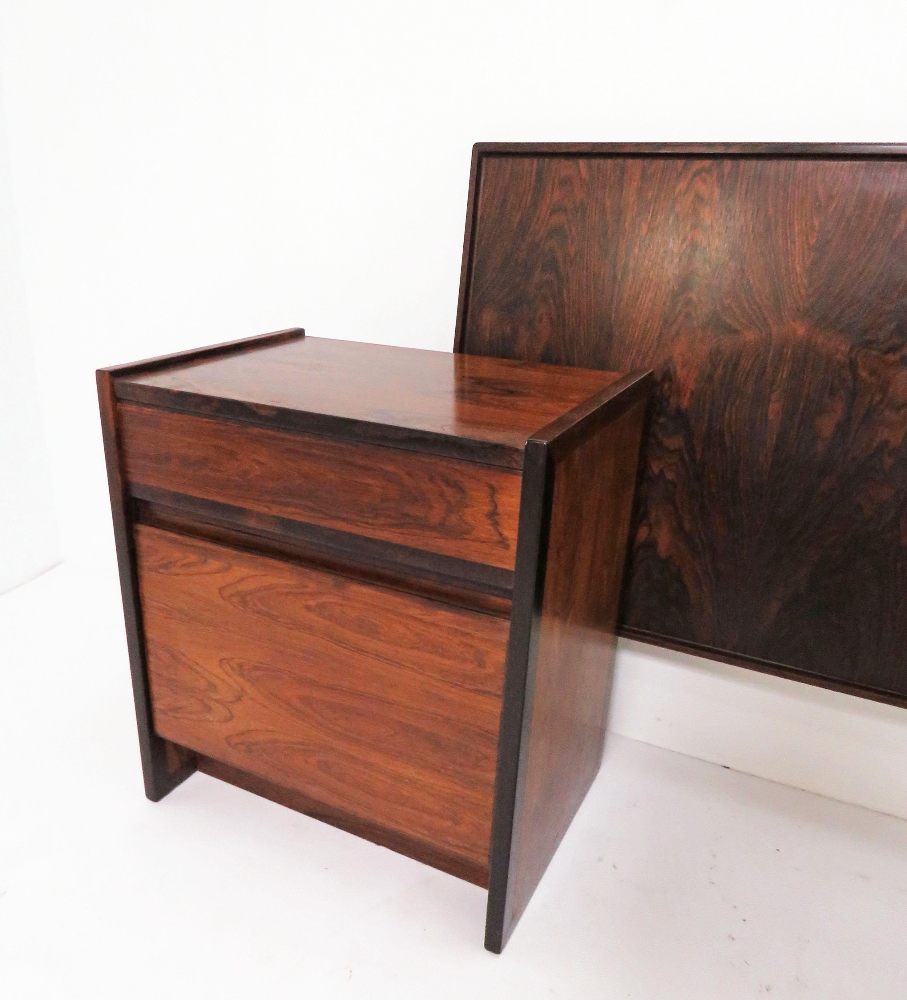 Pair of rosewood night stands and matching king size headboard, circa 1970s. Night stands with drop down door fronts, and single drawer above. Headboard features book matched grain.

Headboard measures 81 5/8