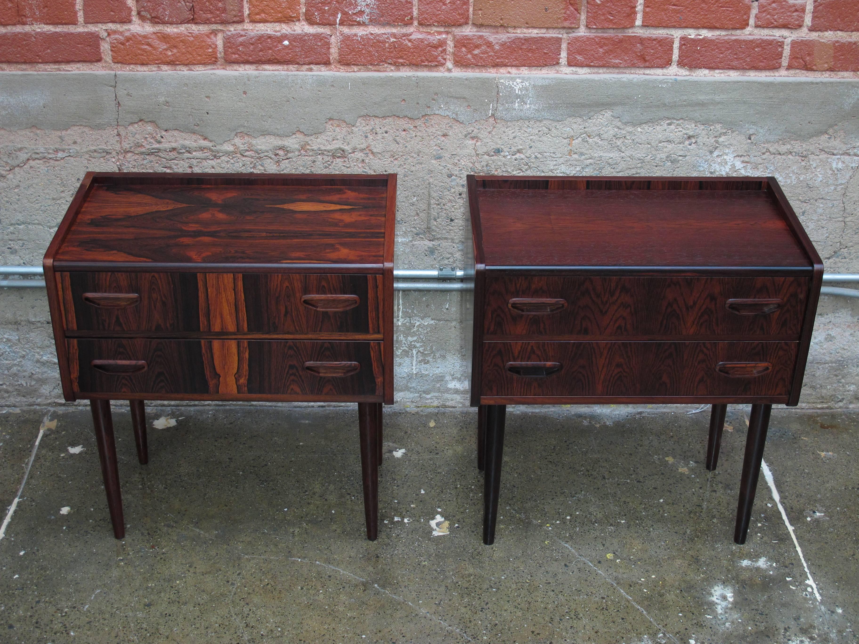 Midcentury nightstand side tables crafted of rosewood veneer with pattern match over solid wood core, each with two drawers raised on solid rosewood legs. Cabinets have been professionally restored and are in excellent condition.